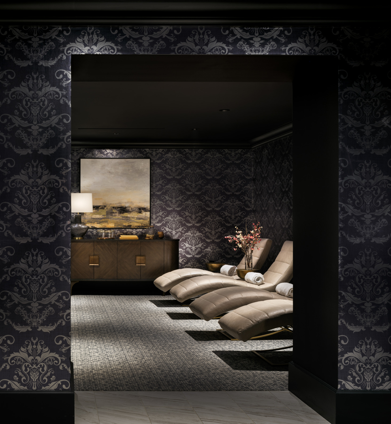 Luxurious spa area with black and silver wallpaper, gold lounge chairs, with bronze furnishings Luxurious spa area with black and silver wallpaper, gold lounge chairs, with bronze furnishings
