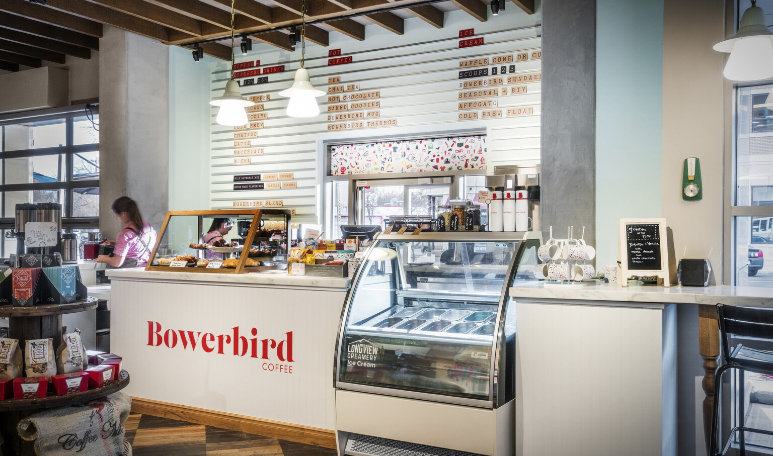 White Bowerbird Coffee counter with marble top and wood pastry display box. Between sections is a Longview Creamery cooler