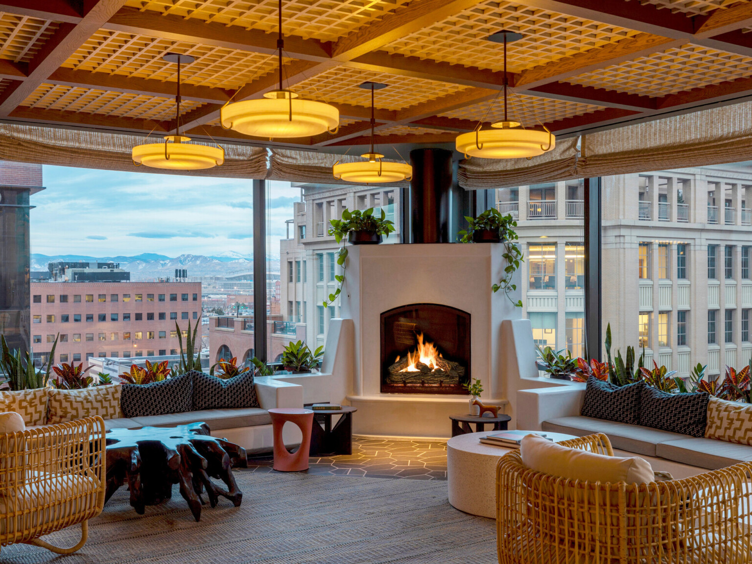 A rooftop lounge on the top of a hotel in Denver overlooking the Downtown and the beyond mountain range