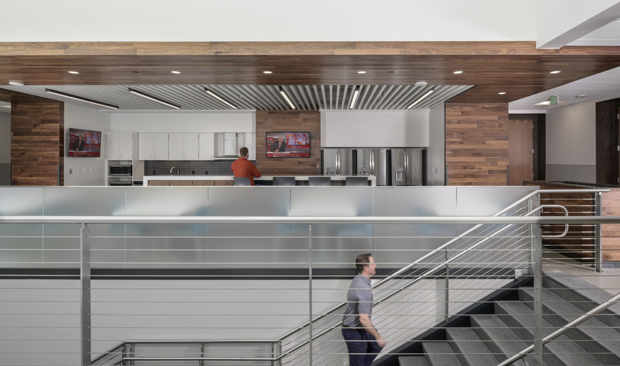 Interior stairwell to kitchen with wood details on walls and mixed media ceiling.