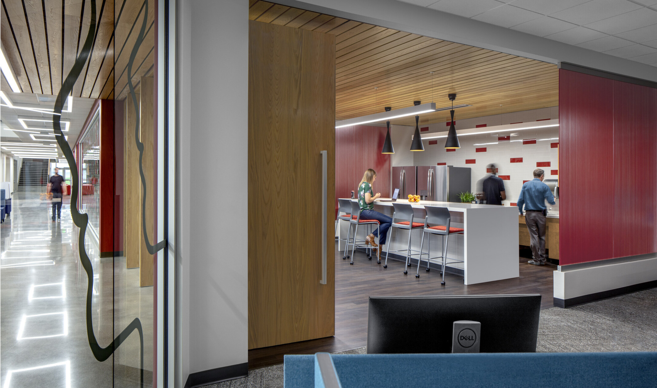 workplace breakroom with red and white tile backsplash with a white counter and multiple high chairs