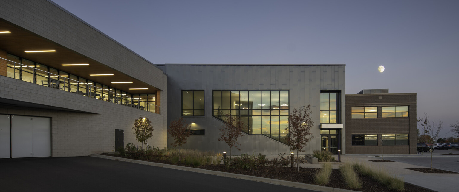 Multistory office building at night showing a brick facade with dimly lit windows