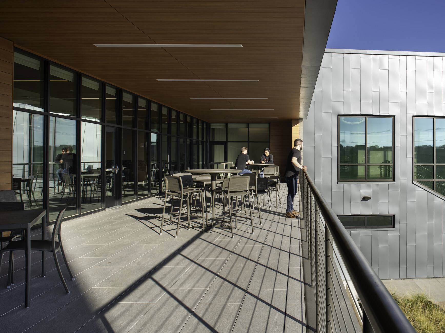 Second story balcony filled with table and chairs overlooking a courtyard