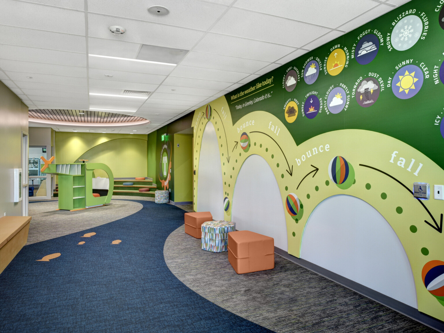 green and yellow walls create visual interest, modular seating area, blue/grey carpet, fluorescent lighting