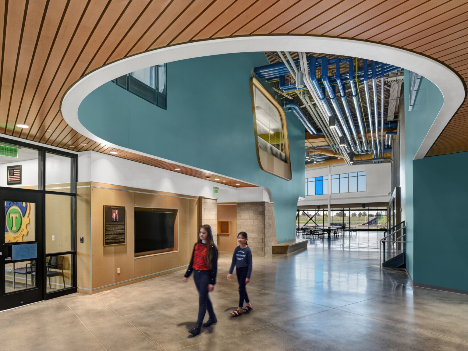 Entryway with large opening in ceiling allows nature to light the room, polished concrete flooring, wood-paneled ceiling