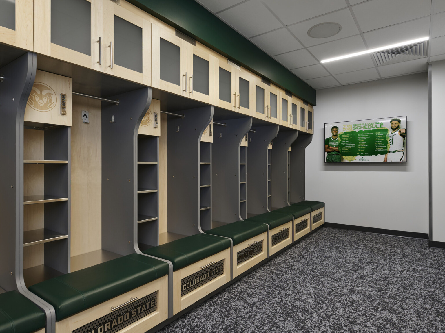 locker room with light colored wood and dark green closets, cubbies, bench seating