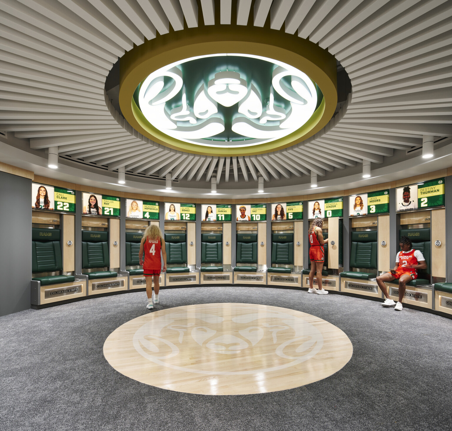 Locker room with grey floors, green seating, grey and wood accents
