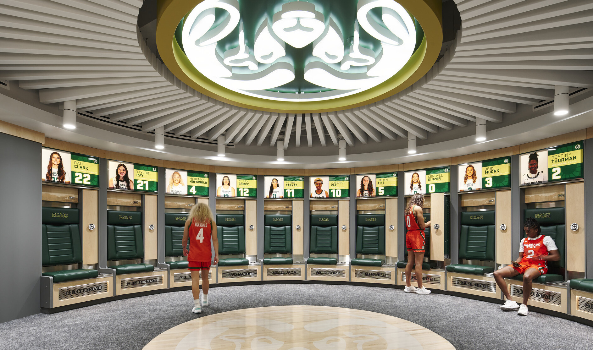Locker room with grey floors, green seating, grey and wood accents