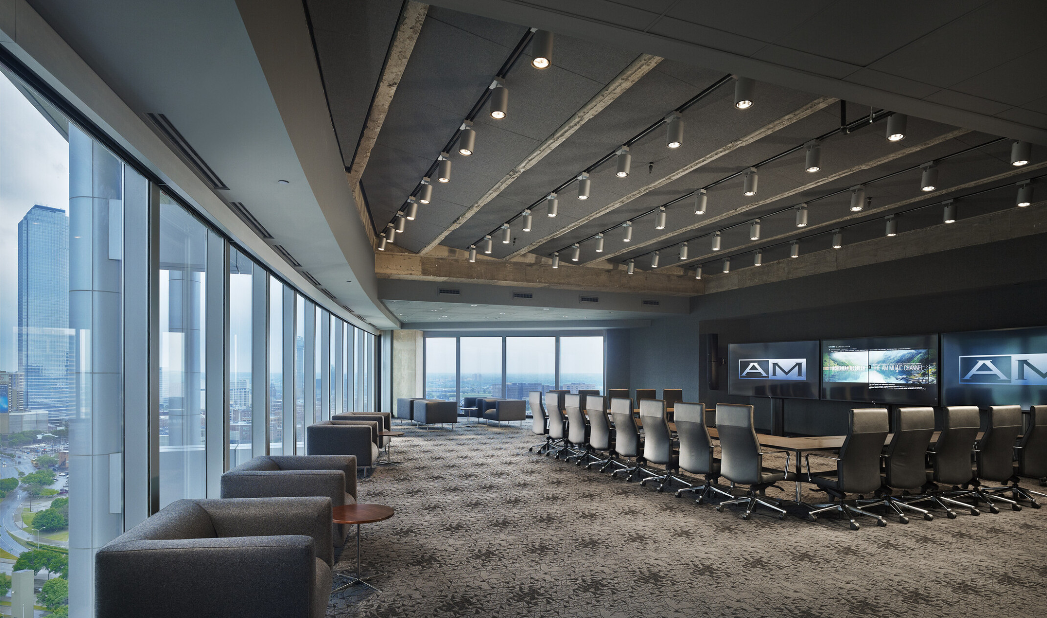 modern, darkly lit and sleek conference board room design with u-shaped table facing tv screens