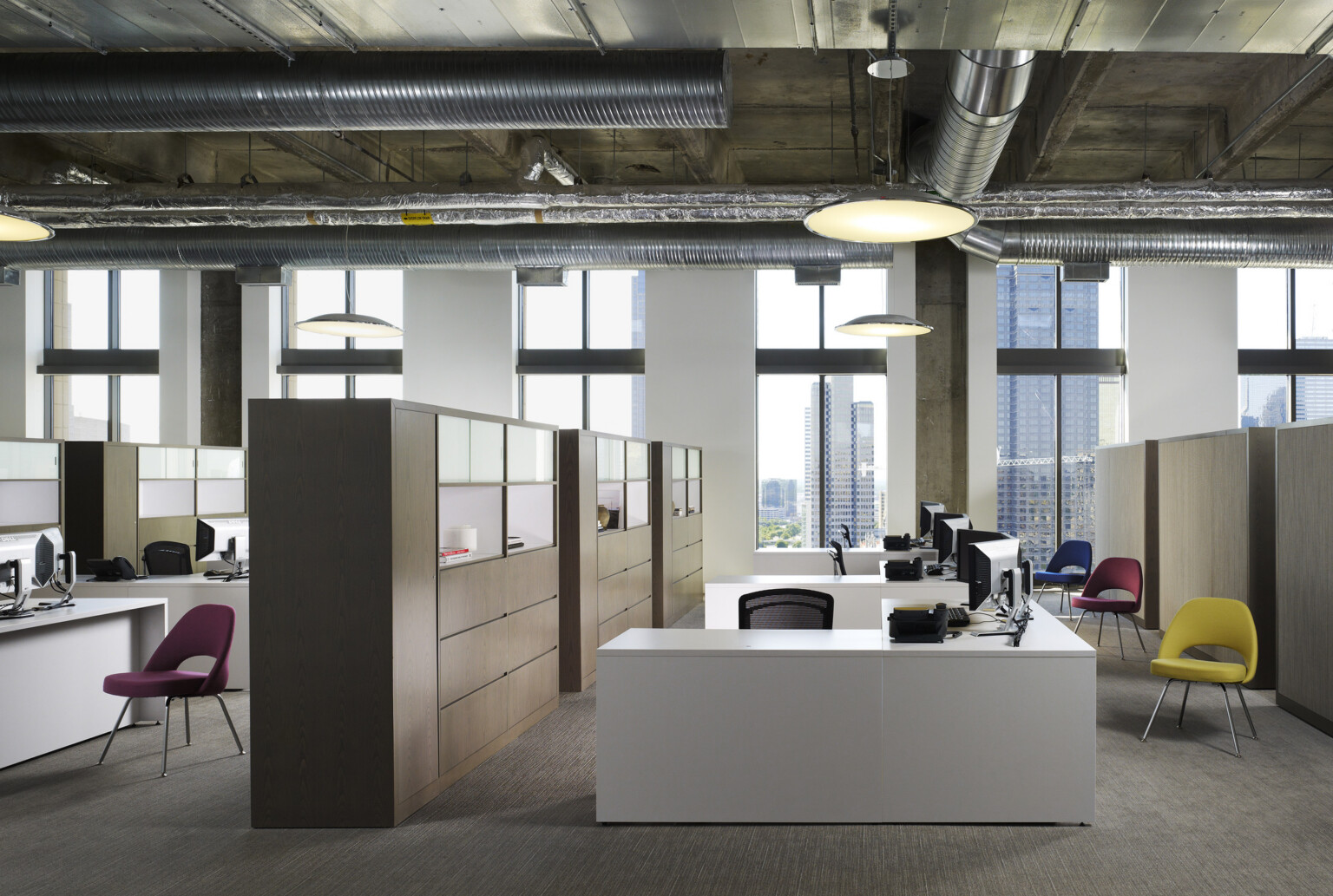 modern workplace interior desk and collaboration space; overlooking floor to ceiling windows with cityscape