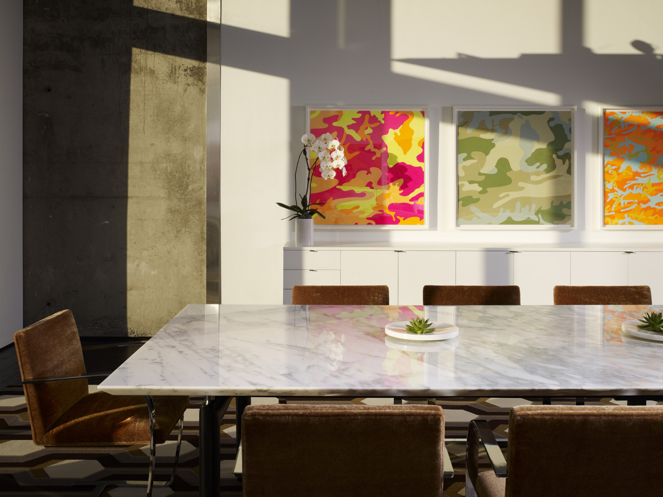 colorful conference room walls with a central feature table overlooking floor to ceiling windows to a cityscape