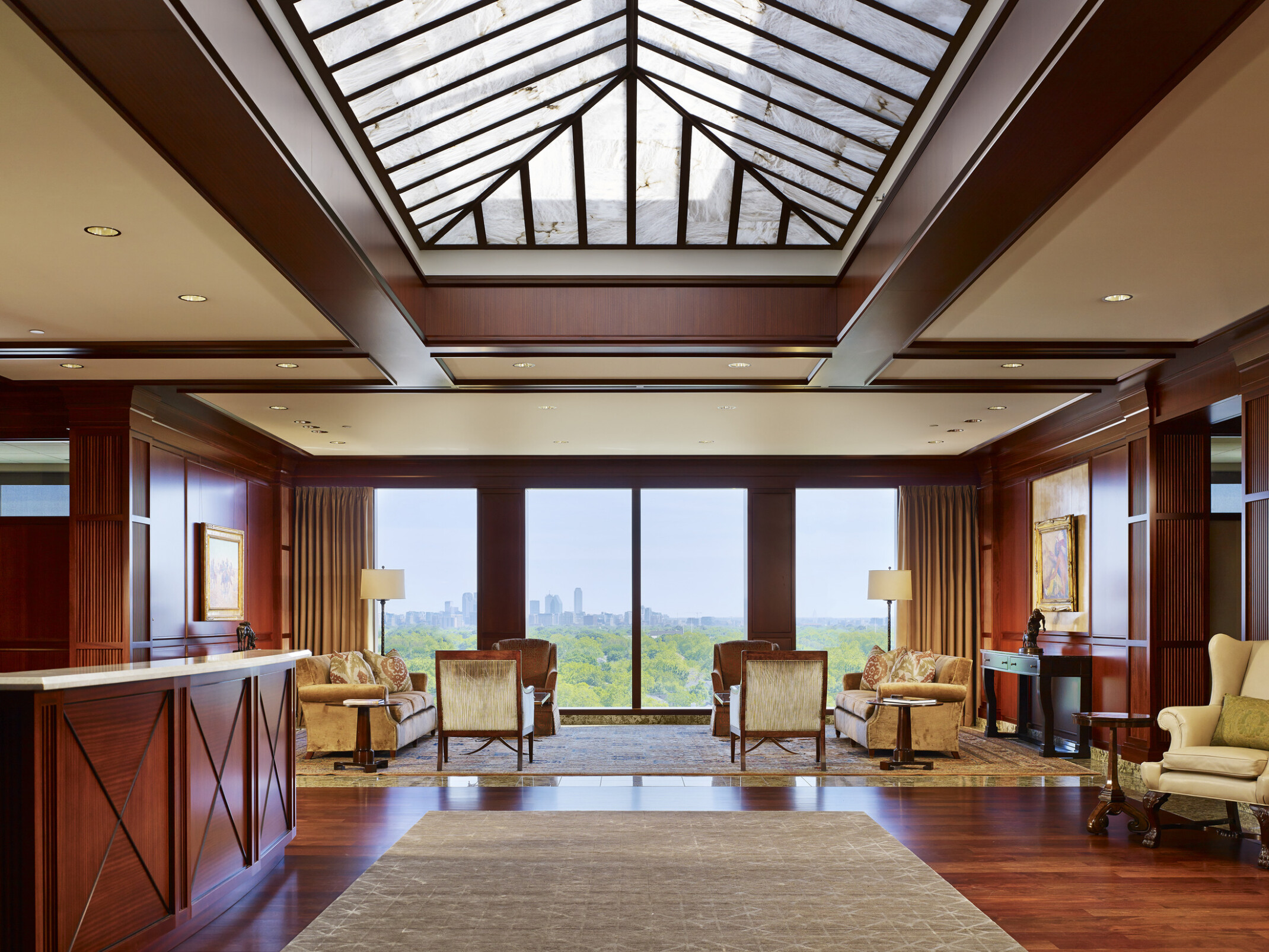 modern workplace interior lobby; warm wood accents and neutral tone walls and furniture; overlooking outdoors and trees