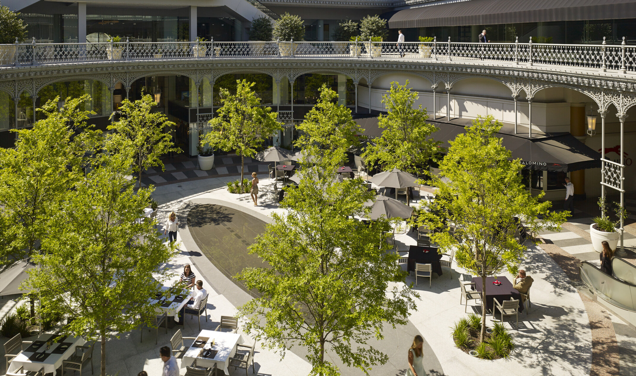 second floor view looking down into an outdoor courtyard with trees and tables