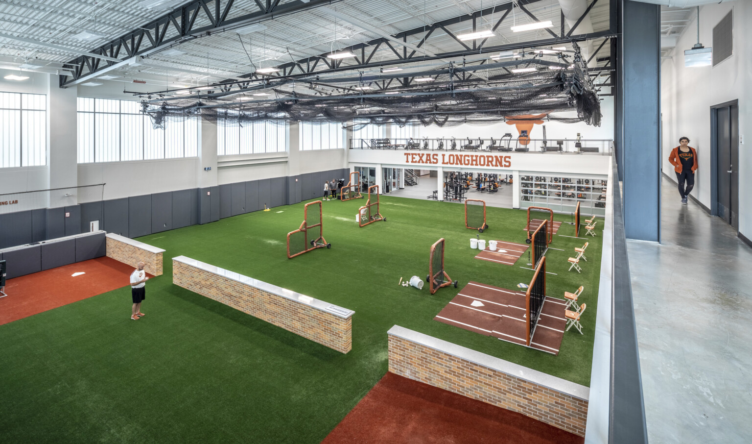 J. Dan Brown Baseball Development Facility at University of Texas interior training space. Turf floor in white room
