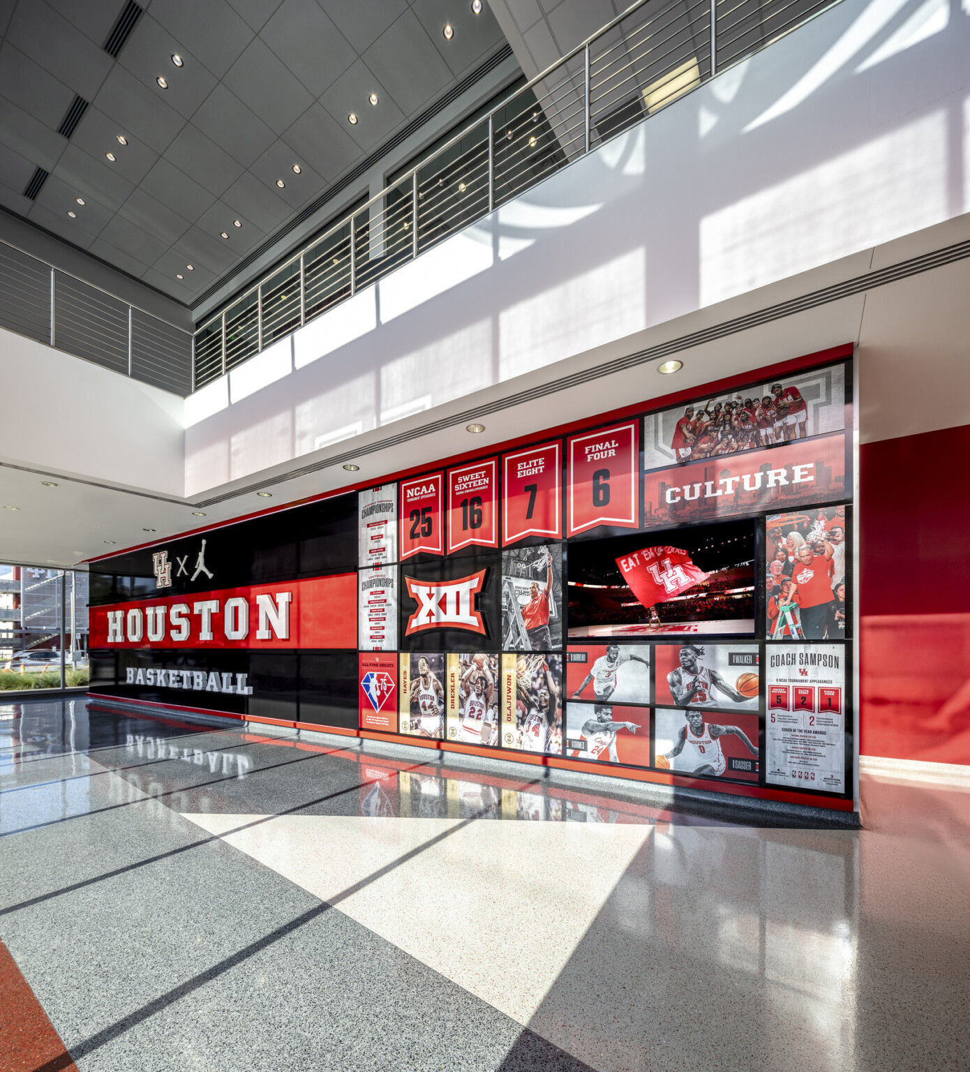 interior of a sports facility; Large black and red "HOUSTON" wall with sports collage of athletes. coaches, awards. stats interior of a sports facility; Large black and red "HOUSTON" wall with sports collage of athletes. coaches, awards. stats