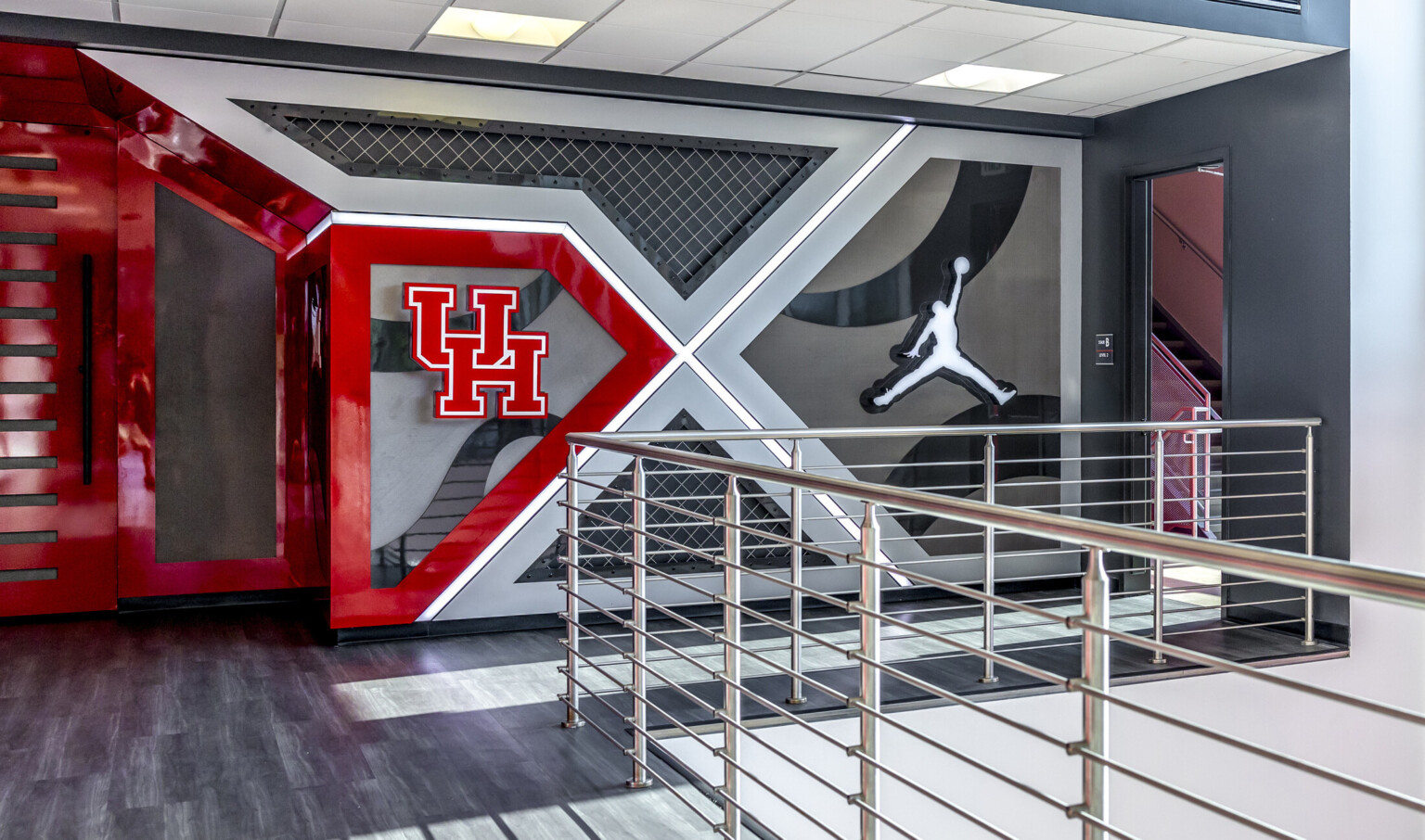 Modern indoor space with UH and Air Jordan logos on a geometric wall design.