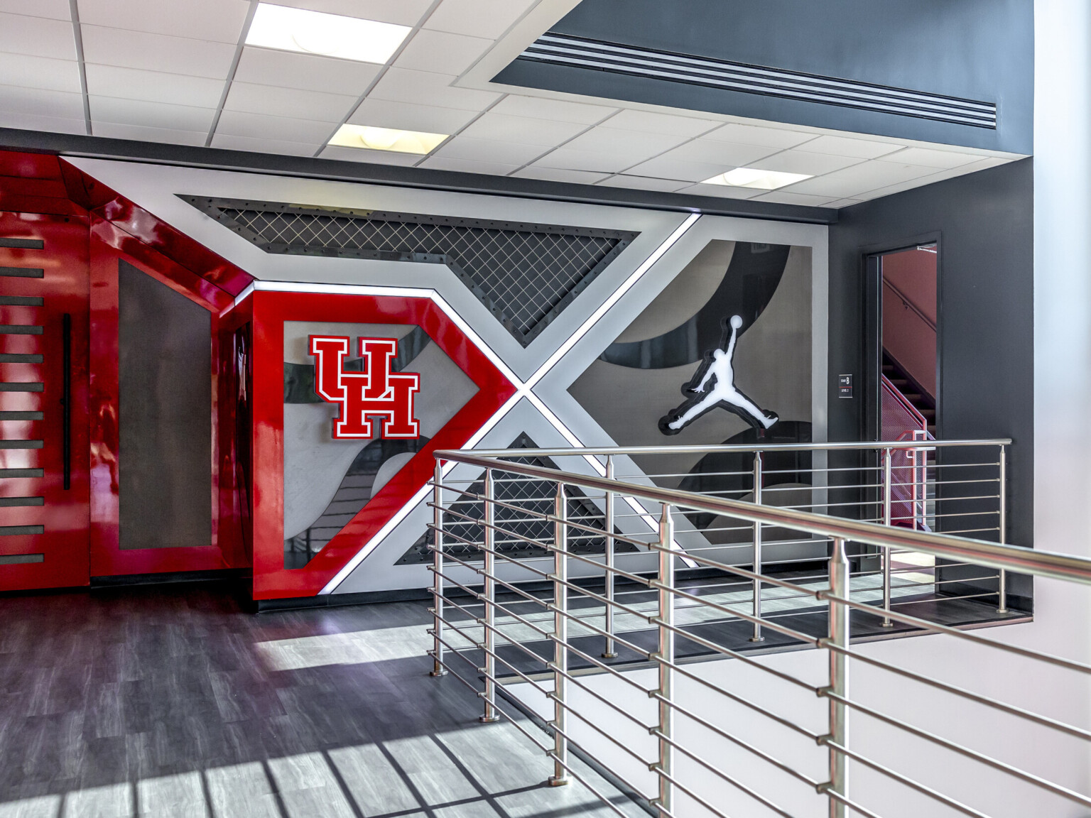 Modern indoor space with UH and Air Jordan logos on a geometric wall design.