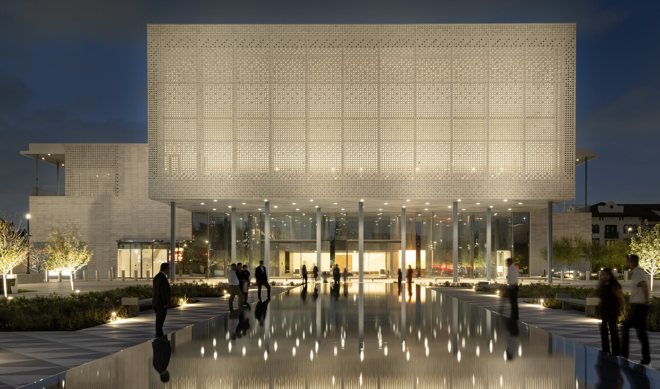 Intricately patterned screens on the building exterior make the building appear as if it is glowing from within.