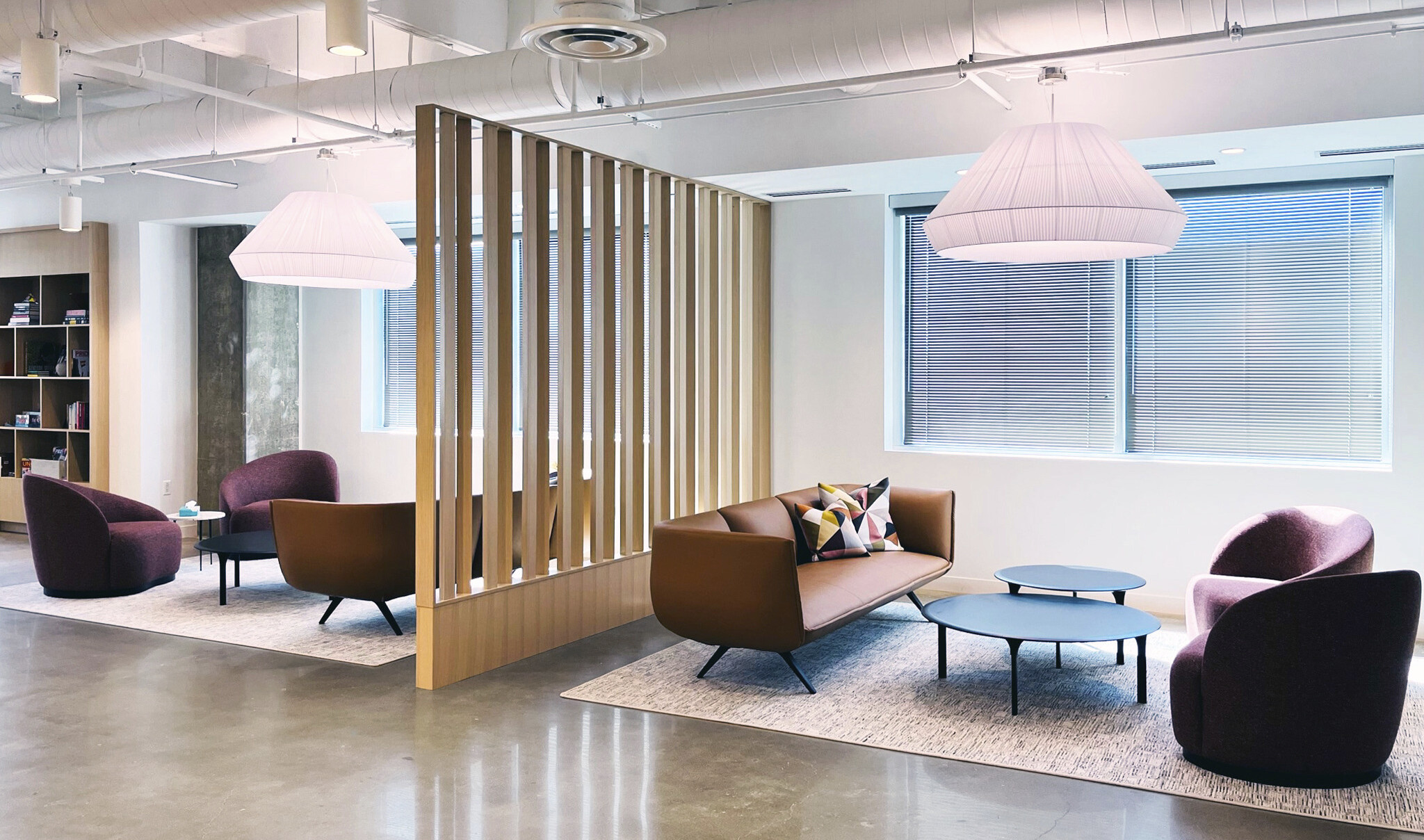 polished concrete floors, painted white exposed ceiling with seating clusters separated by free standing wood panel dividers