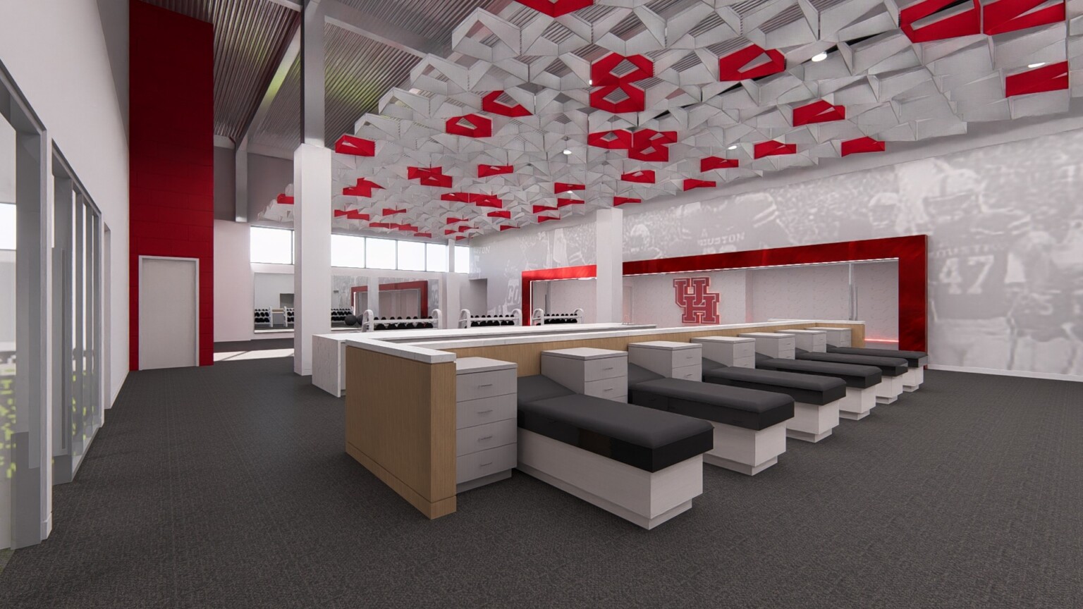 Sports medicine room with exam tables, modern artwork on the ceiling and wall murals highlighted by red accents
