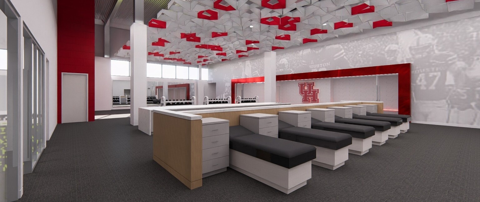 Sports medicine room with exam tables, modern artwork on the ceiling and wall murals highlighted by red accents
