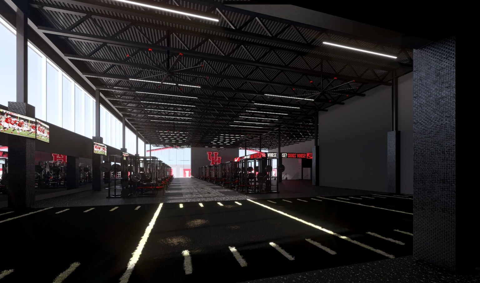 Dimly lit athletic training facility; small turf area in the foreground; weightlifting machines in the background; University of Houston logo along the back wall