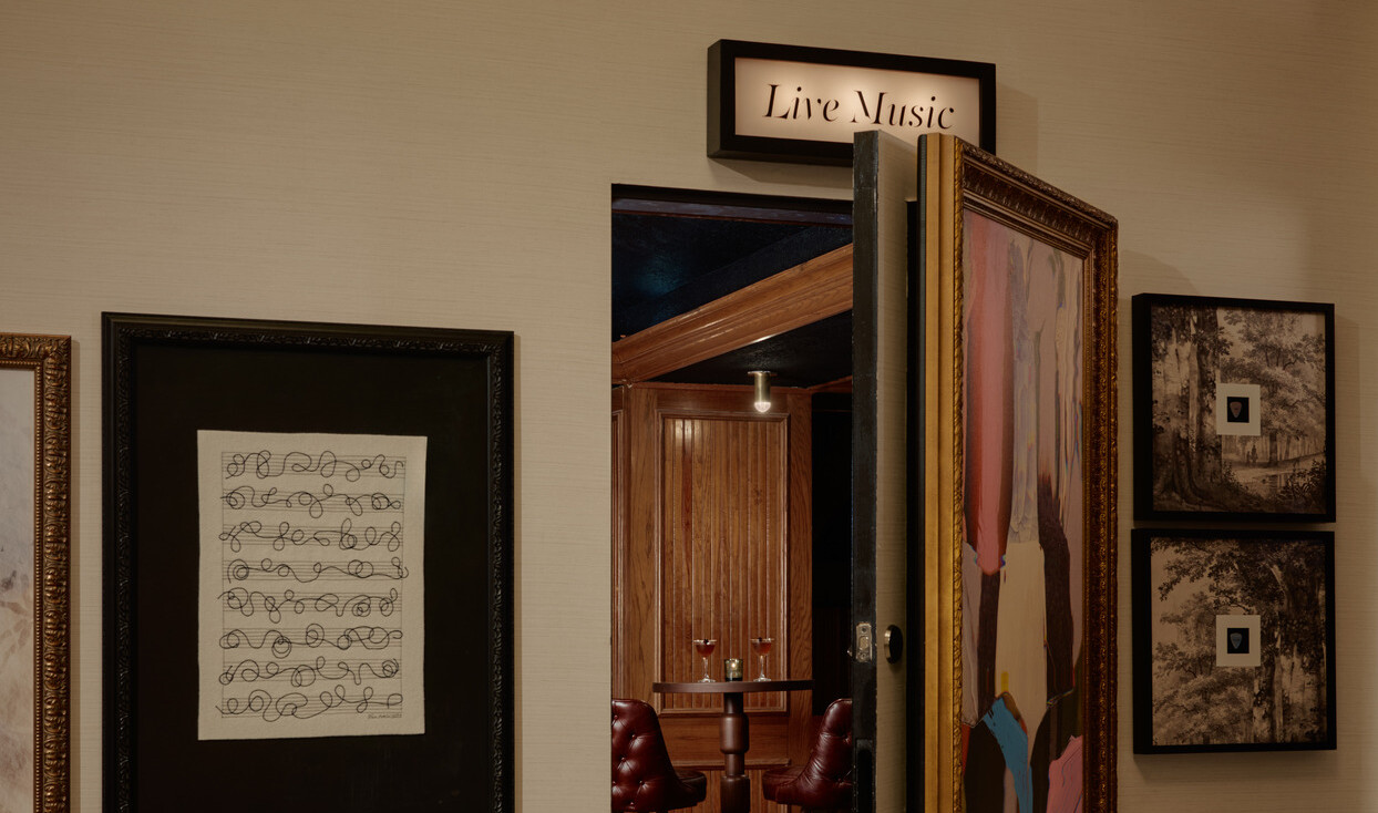 A hidden door in the gallery wall opens to Bar 414, the Gunter Hotel’s speakeasy, with drinks on a high-top table.