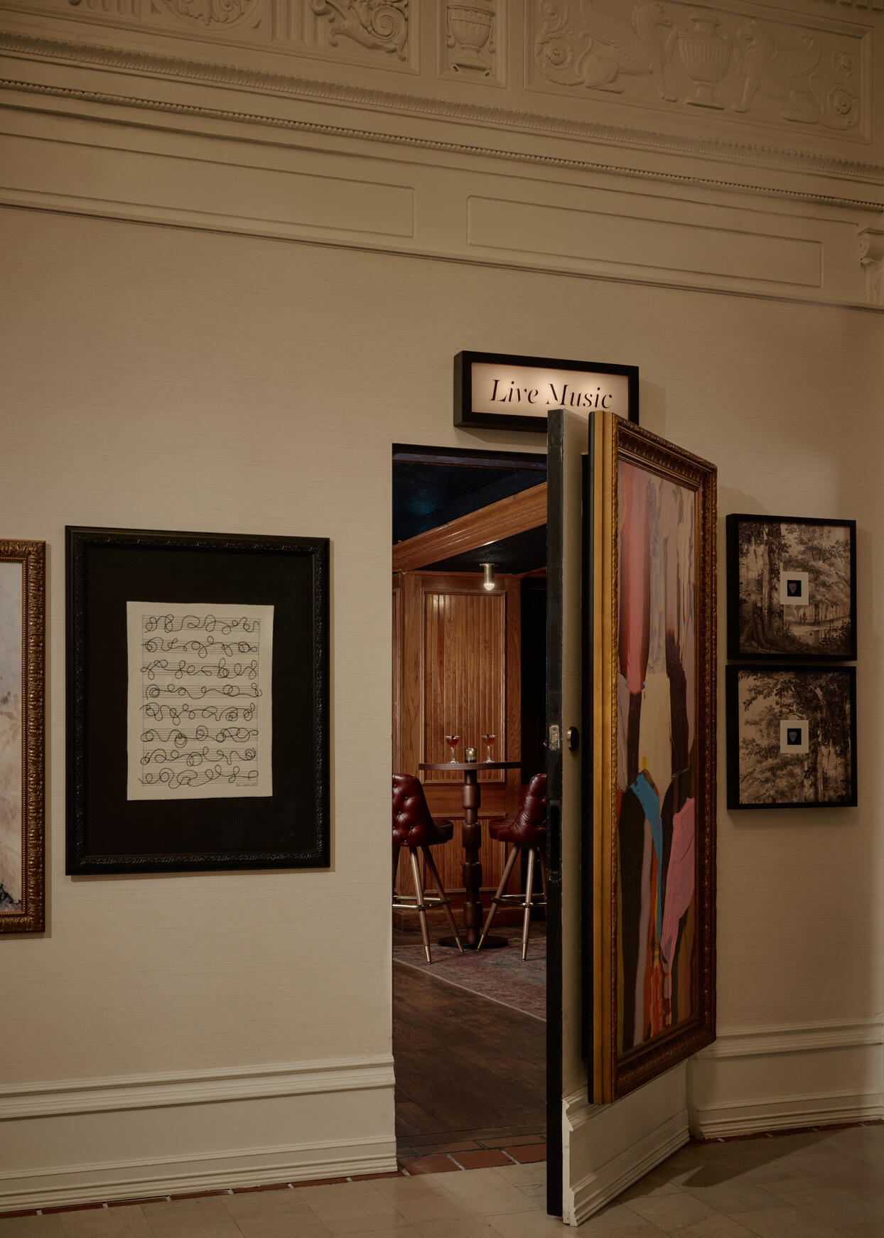 A hidden door in the gallery wall opens to Bar 414, the Gunter Hotel’s speakeasy, with drinks on a high-top table.