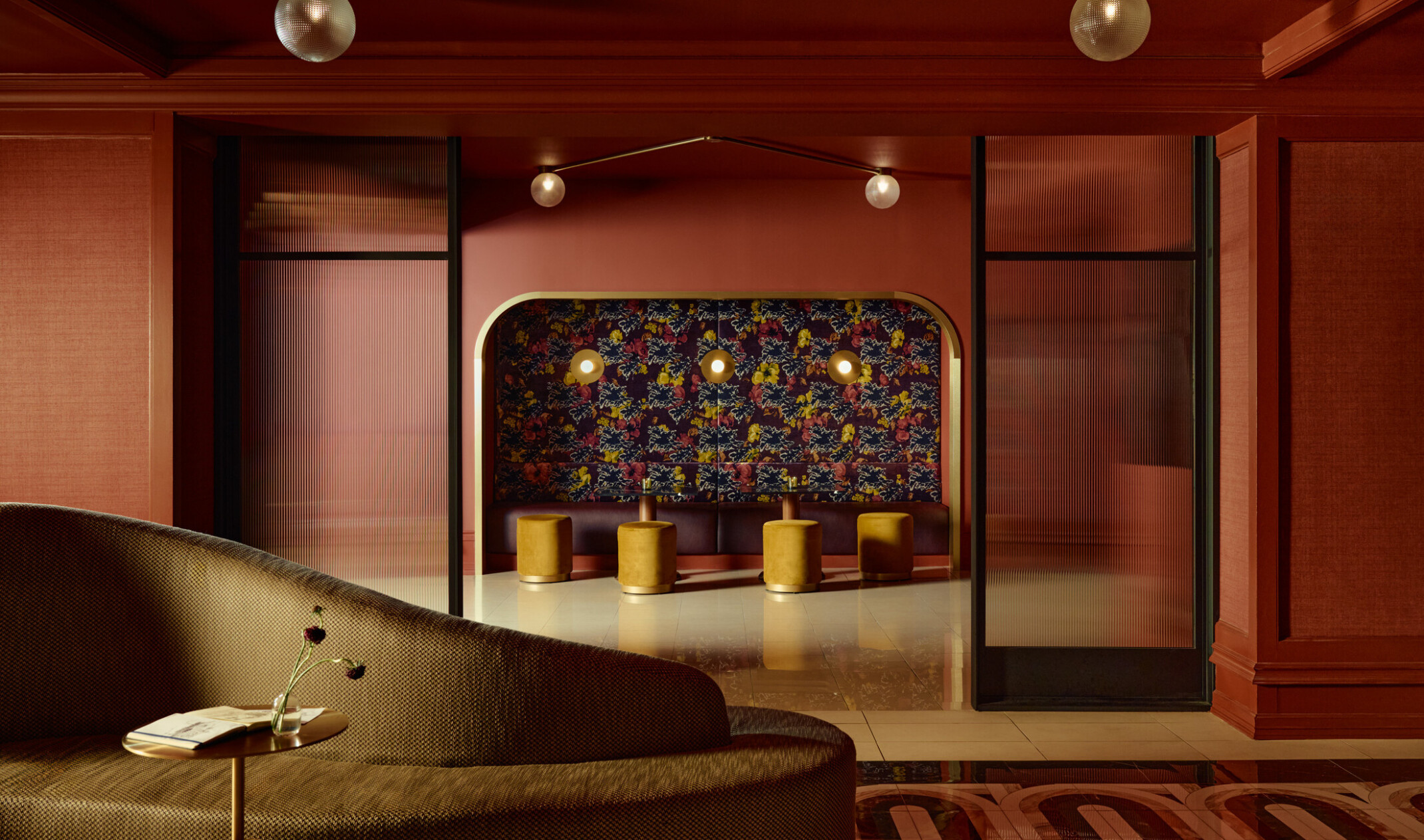 interior of a hotel lounge; maroon wood walls surround stylistic furniture