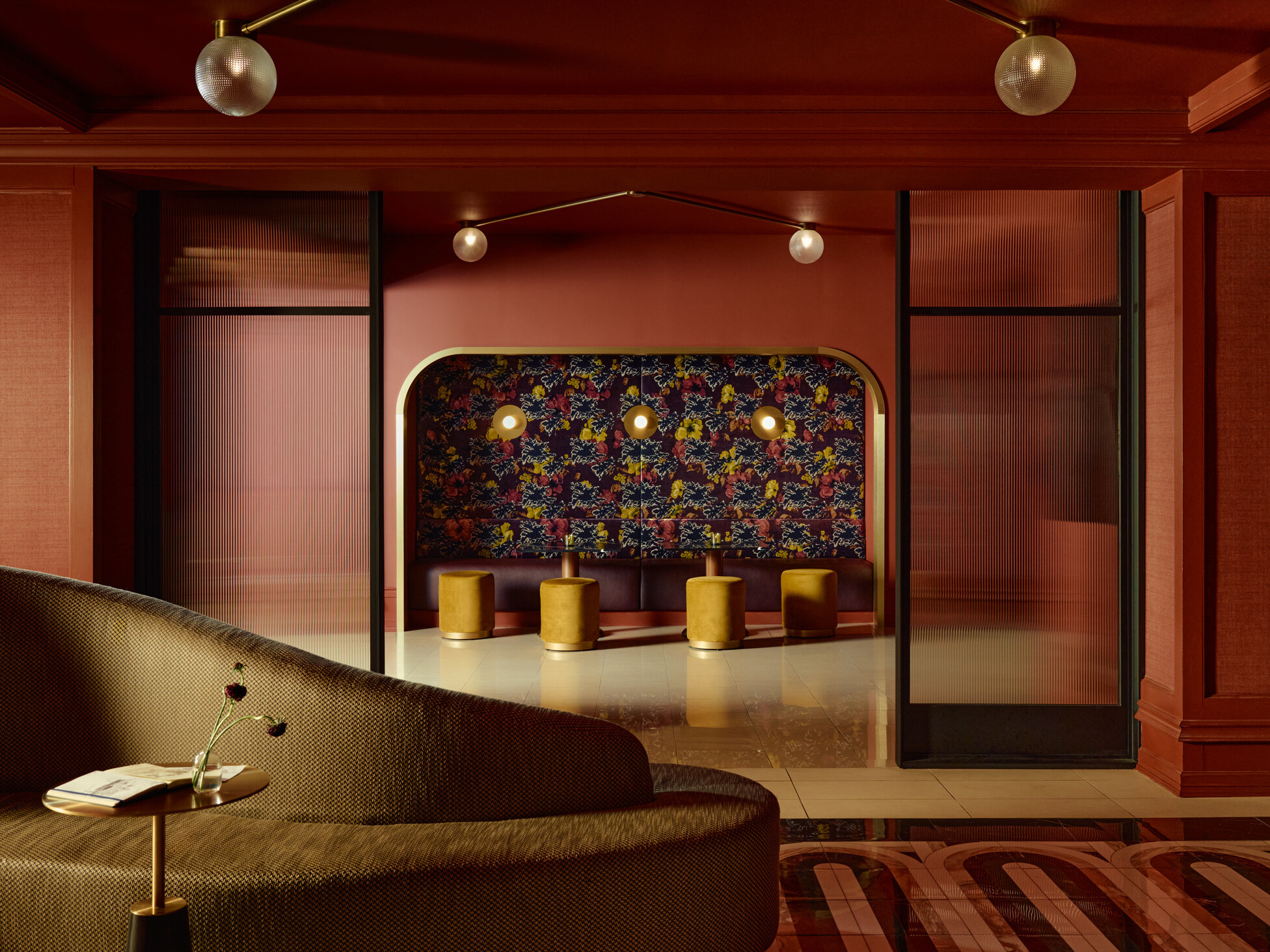 interior of a hotel lounge; maroon wood walls surround stylistic furniture
