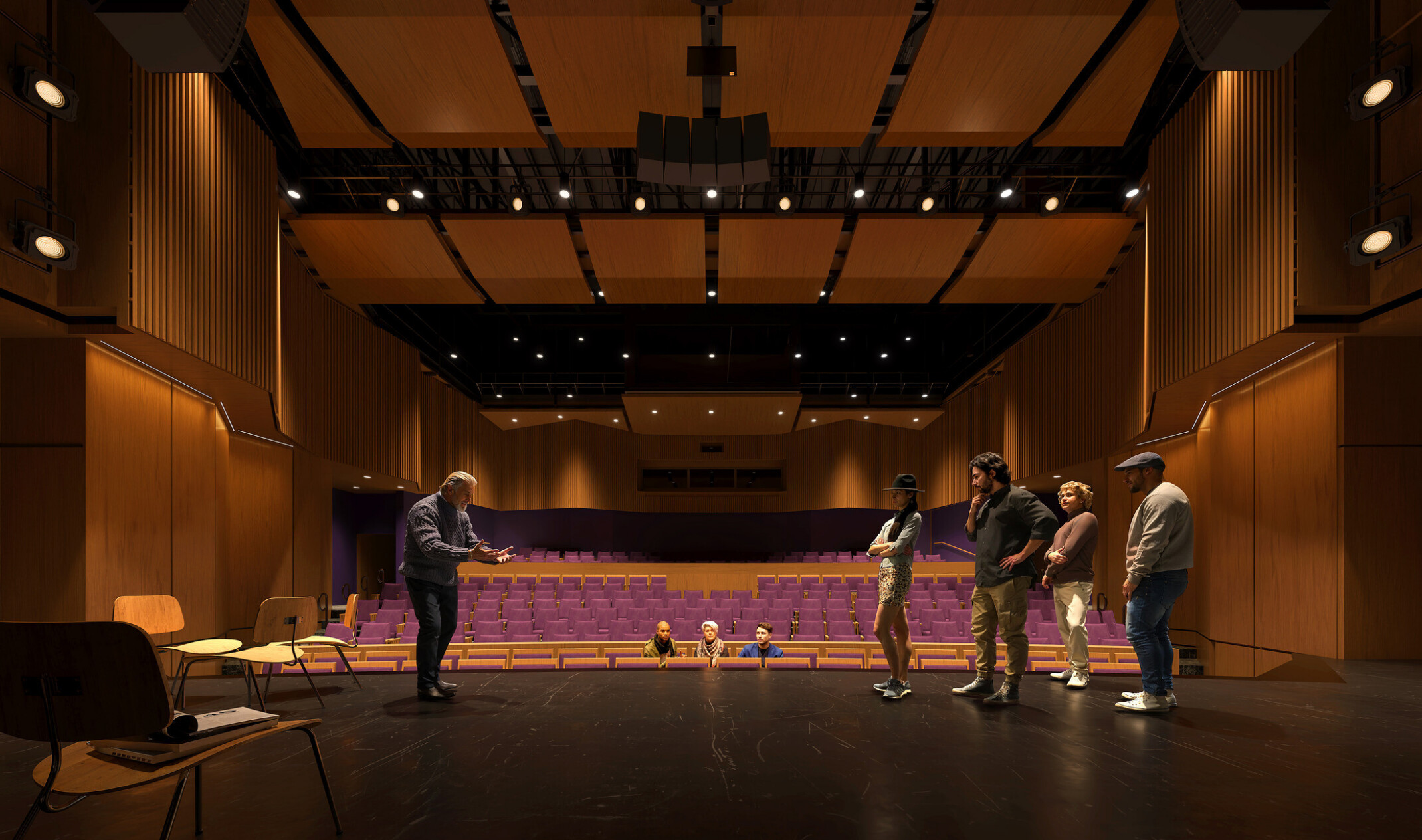 view of an auditorium from back of stage to house; people rehearsing on an empty stage