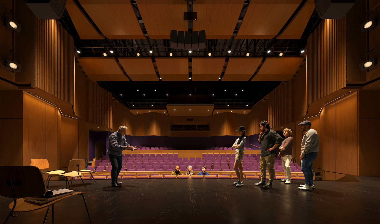 view of an auditorium from back of stage to house; people rehearsing on an empty stage