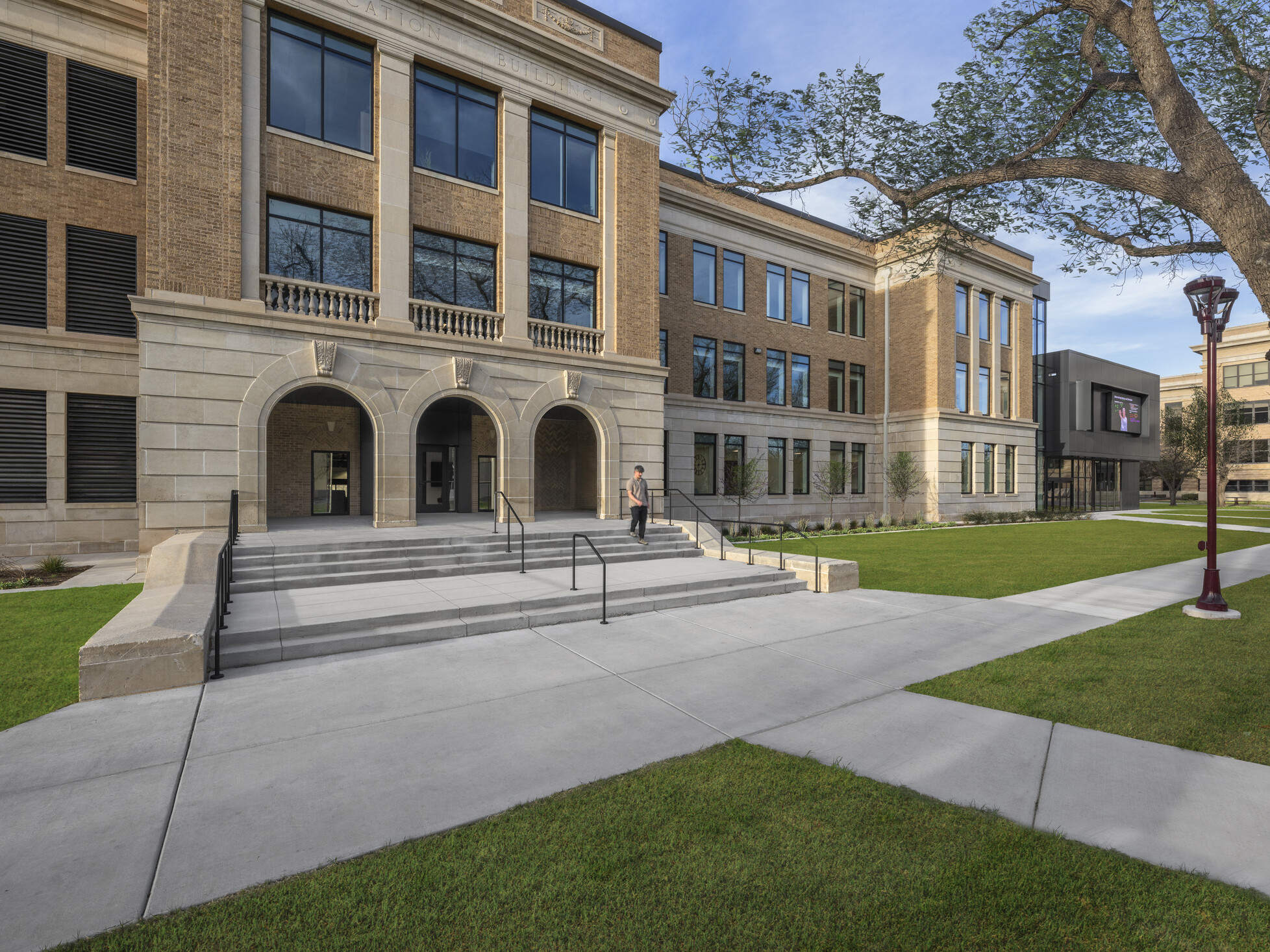entrance to a historic university building; light brick and marble facade with grand staircase entrance