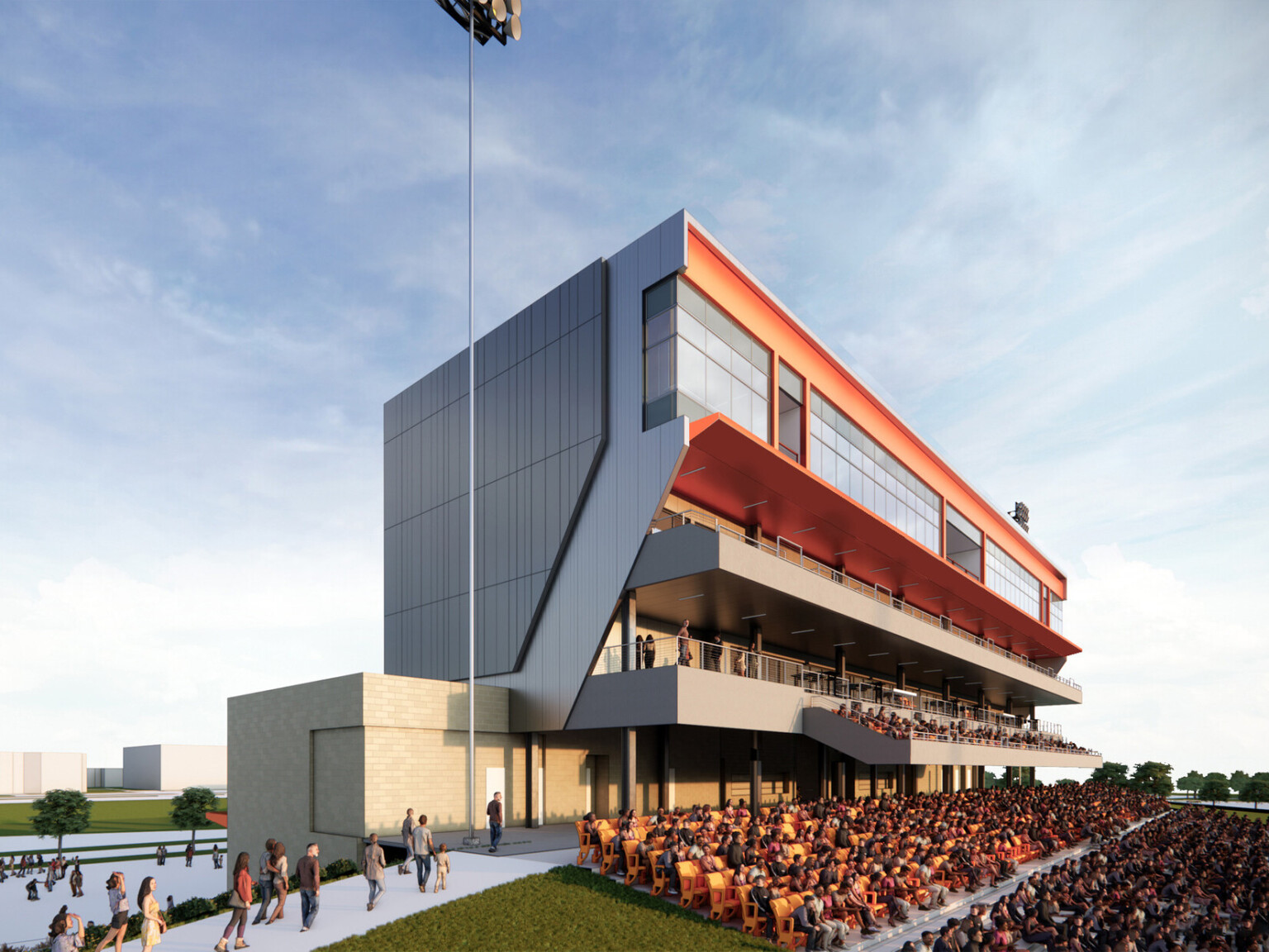 Modern sports stadium grandstand filled with spectators in orange seats below a large tower filled with windows and balconies