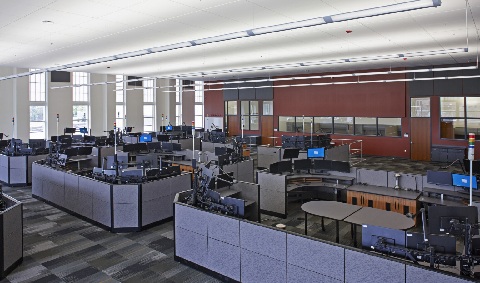 Interior call center office space with cubicles filled with desks with multiple monitors