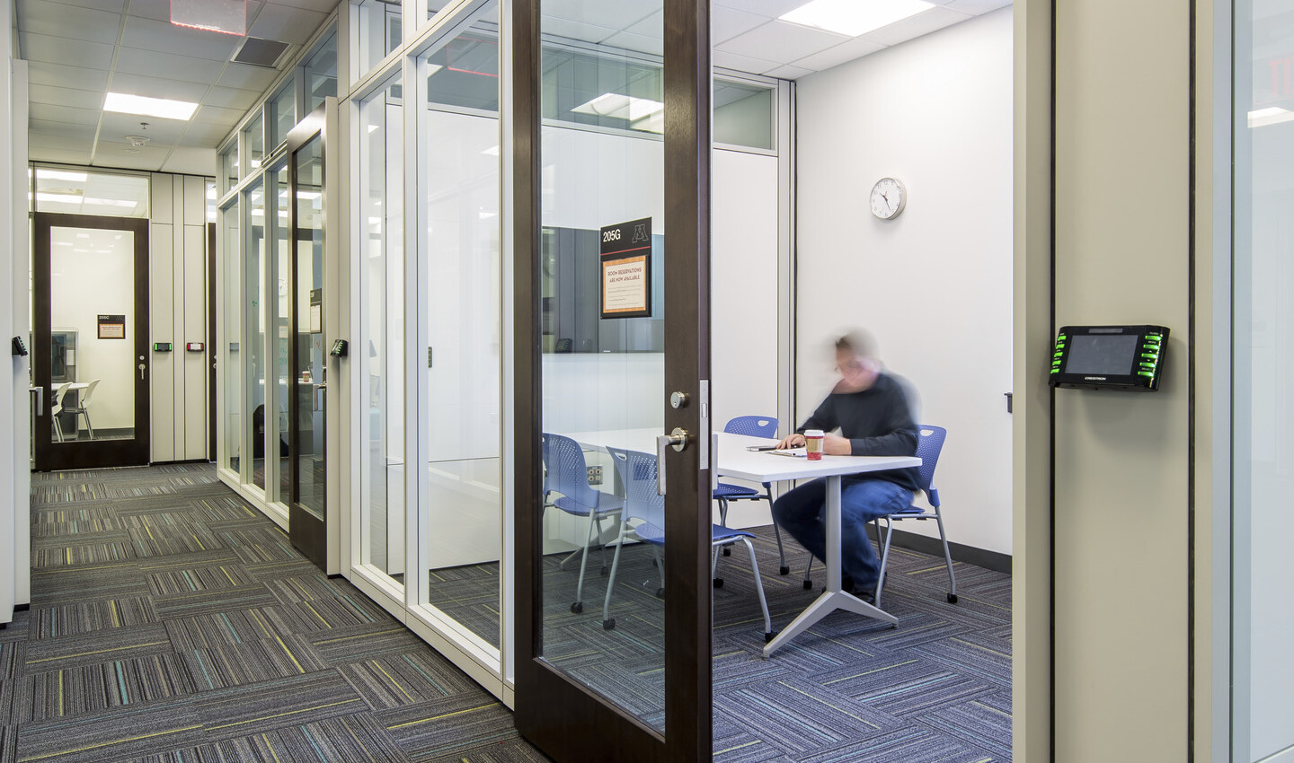 man working in a private room with glass walls and door off a hallway in the University of Minnesota Student Cultural Center man working in a private room with glass walls and door off a hallway in the University of Minnesota Student Cultural Center