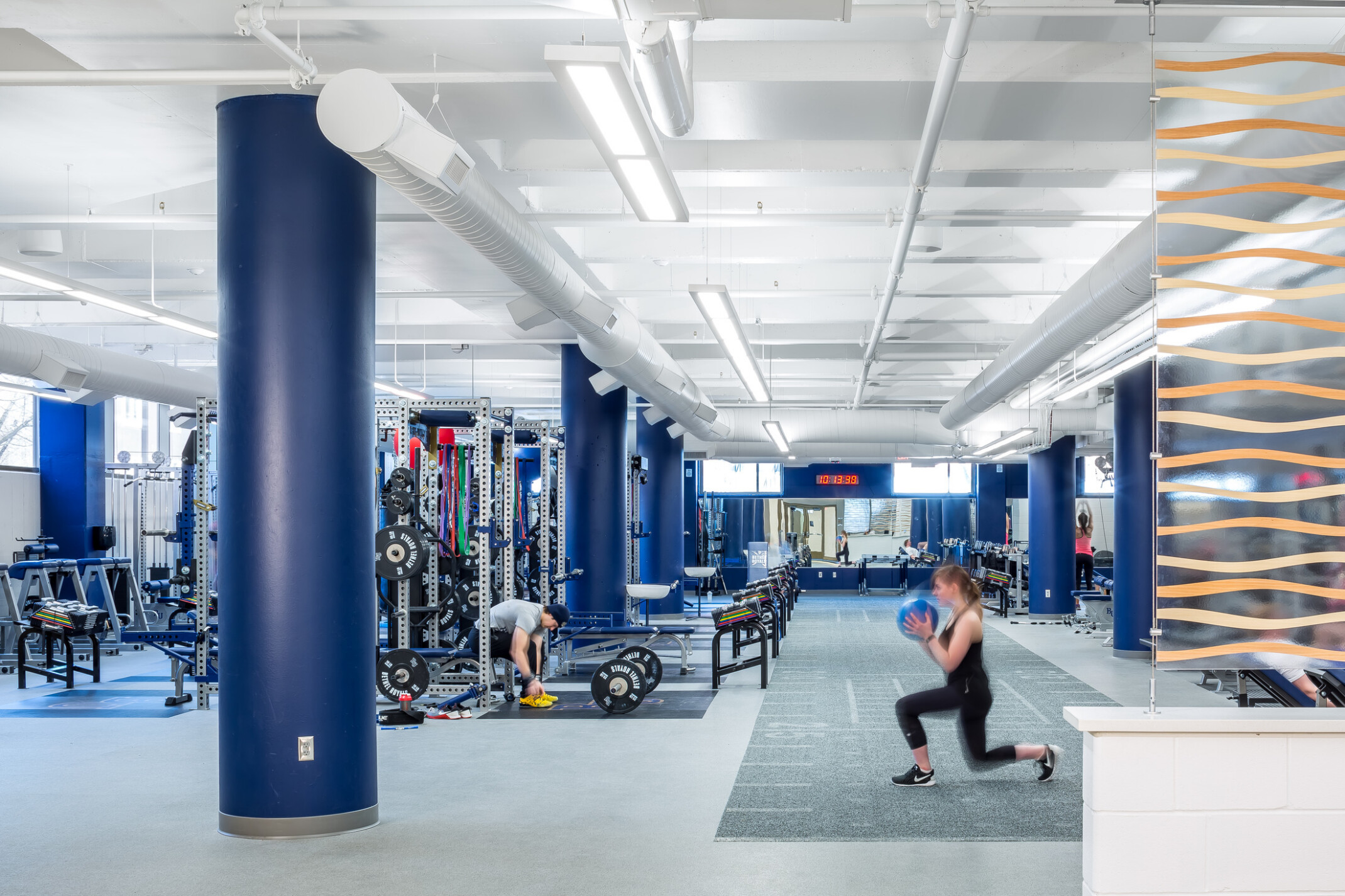 modern gym space with people working out and machines in the background