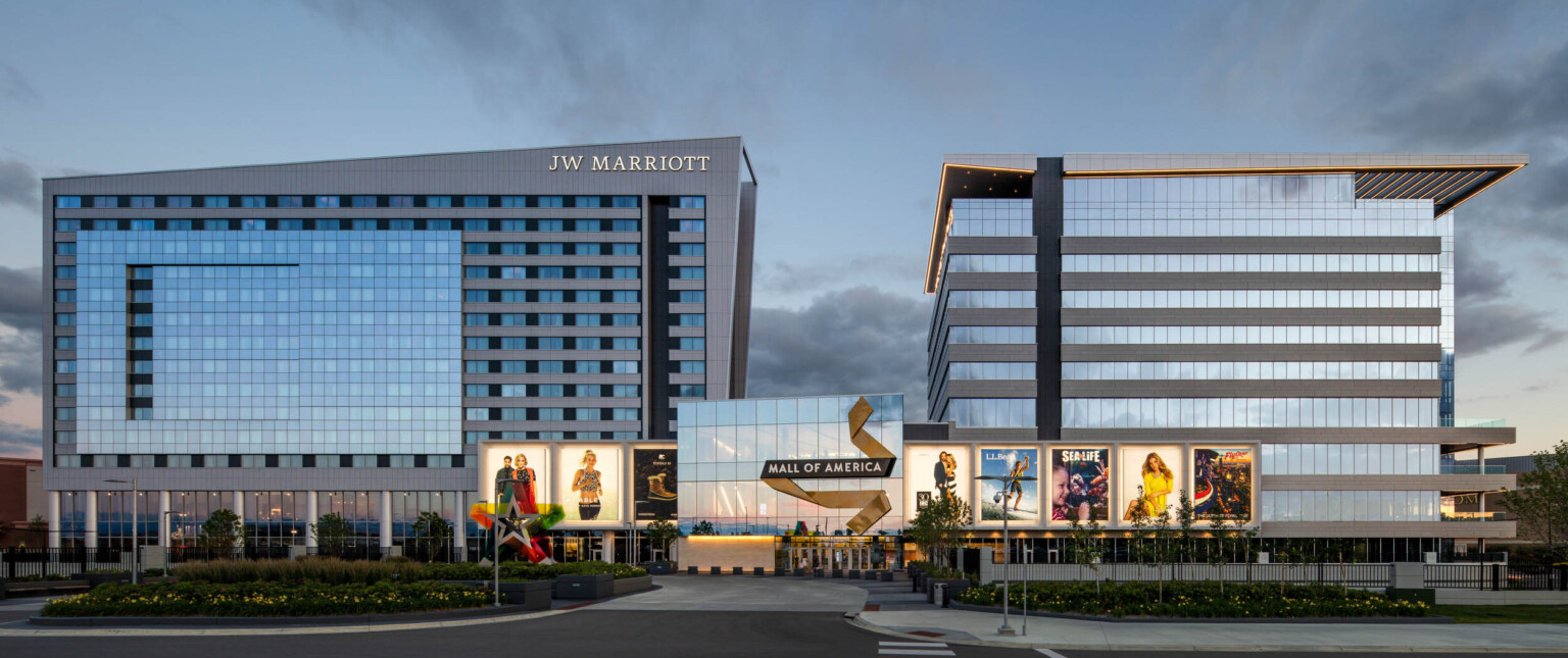 Mall of America entry with illuminated signage connecting 2 grey angled buildings. Left building labelled JW Marriott