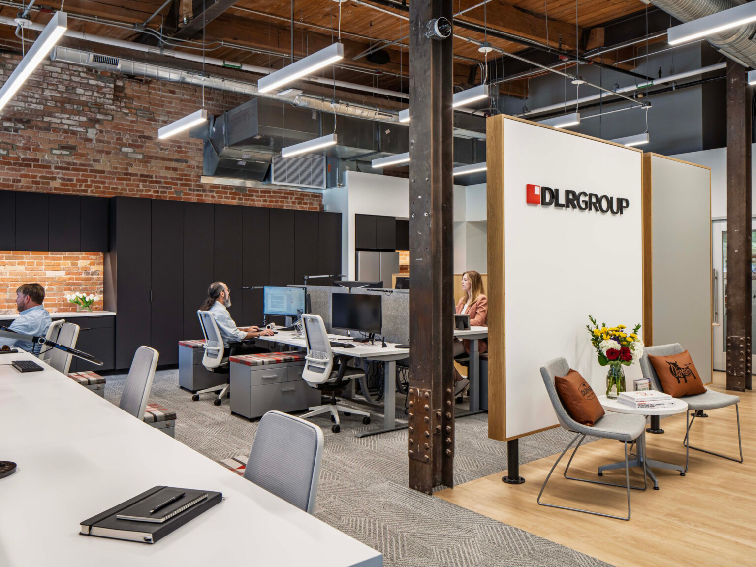 modern office with cubicles and a small seating area in front; DLR Group Durham office