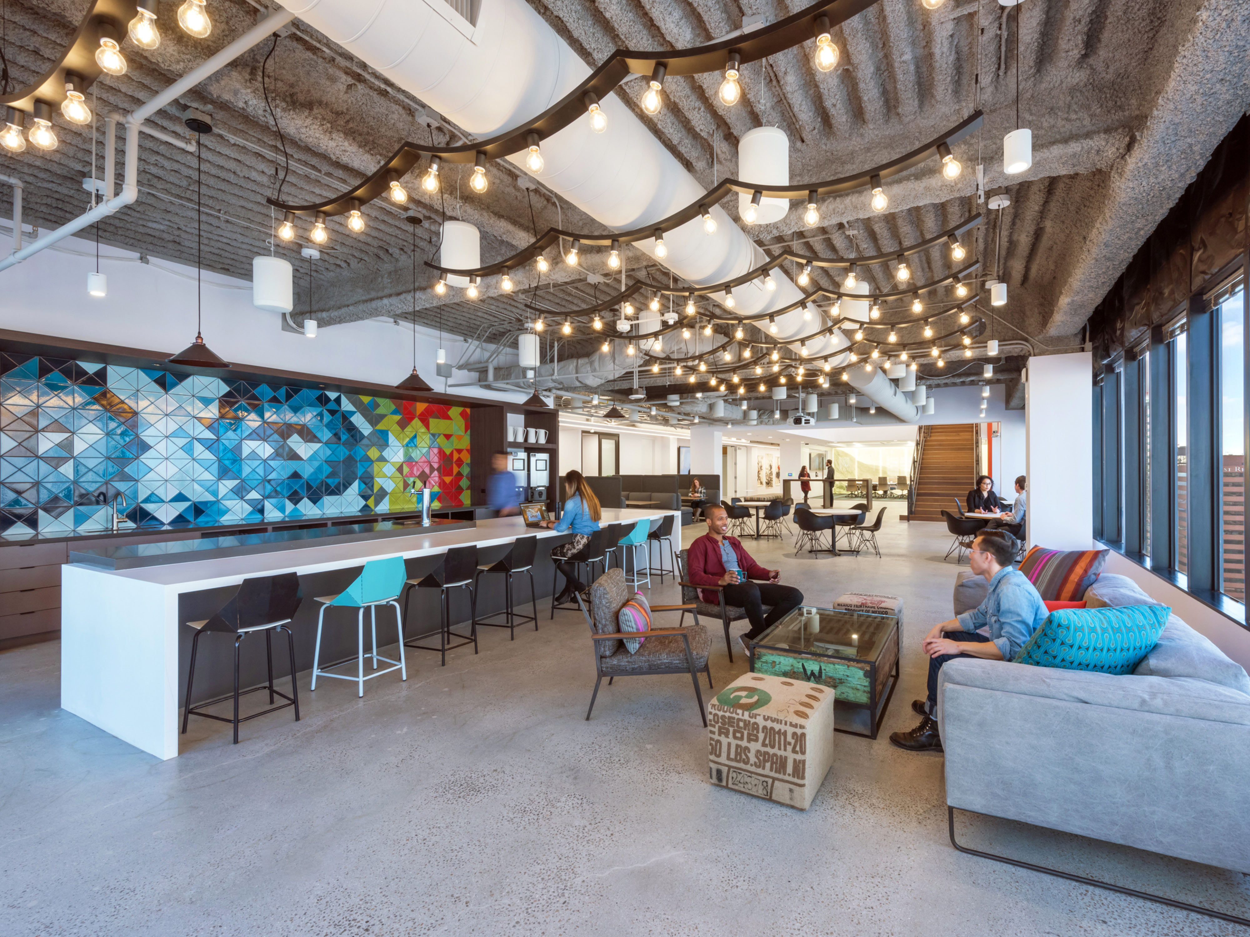 modern office with communal kitchen and counterspace along with couches and chairs; DLR Group LA office