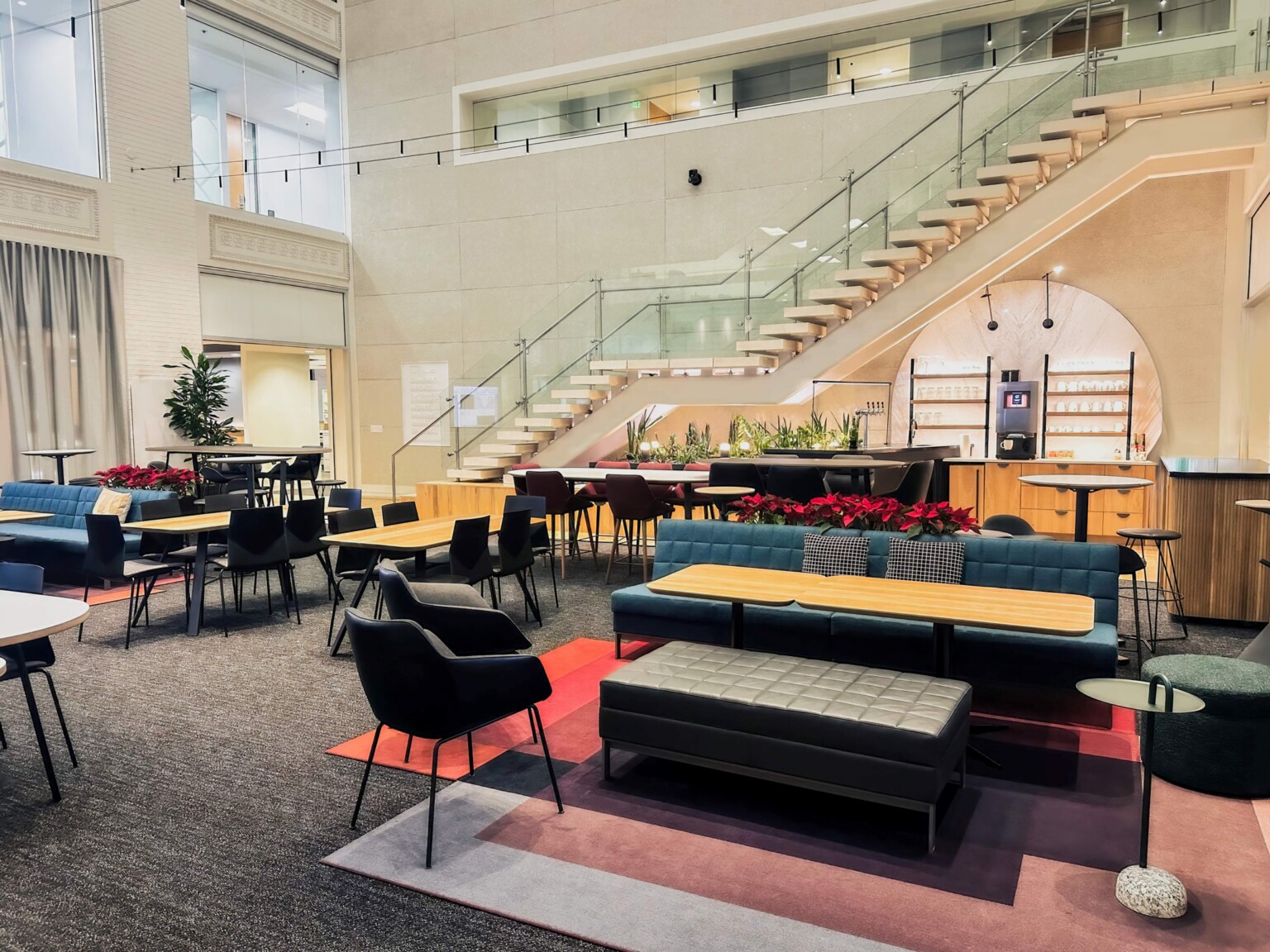 modern office collaboration and lunch center with staircase upstairs in background; DLR Group Minneapolis office
