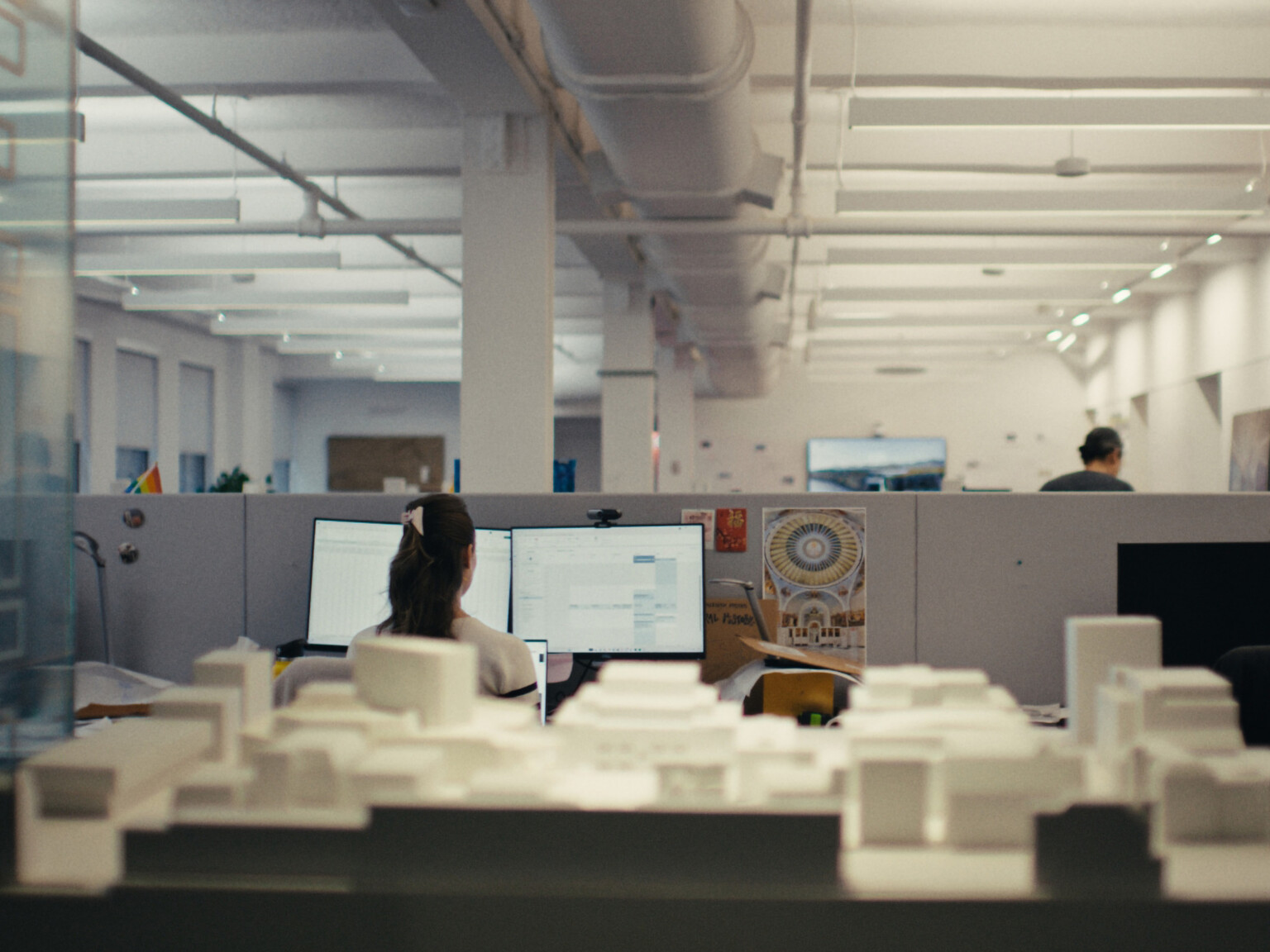 Modern office cubicle with building models in foreground; DLR Group new york office