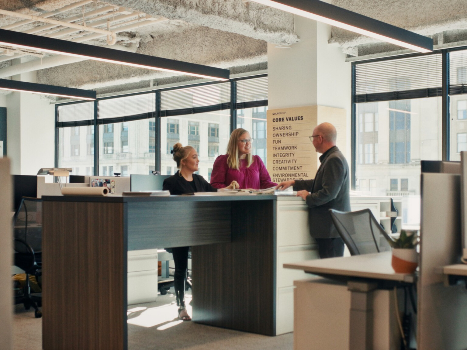 modern office collaboration hub with people talking; DLR Group Nashville office