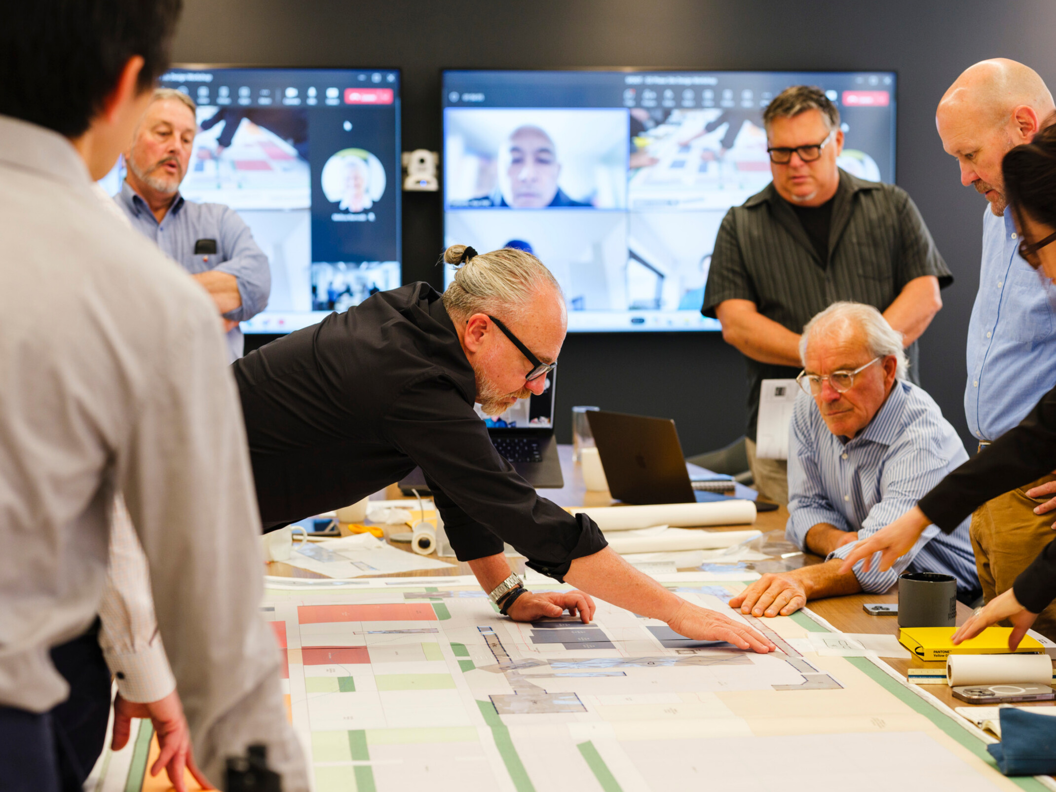 people collaborating over a schematic design at a table; DLR Group San Francisco office
