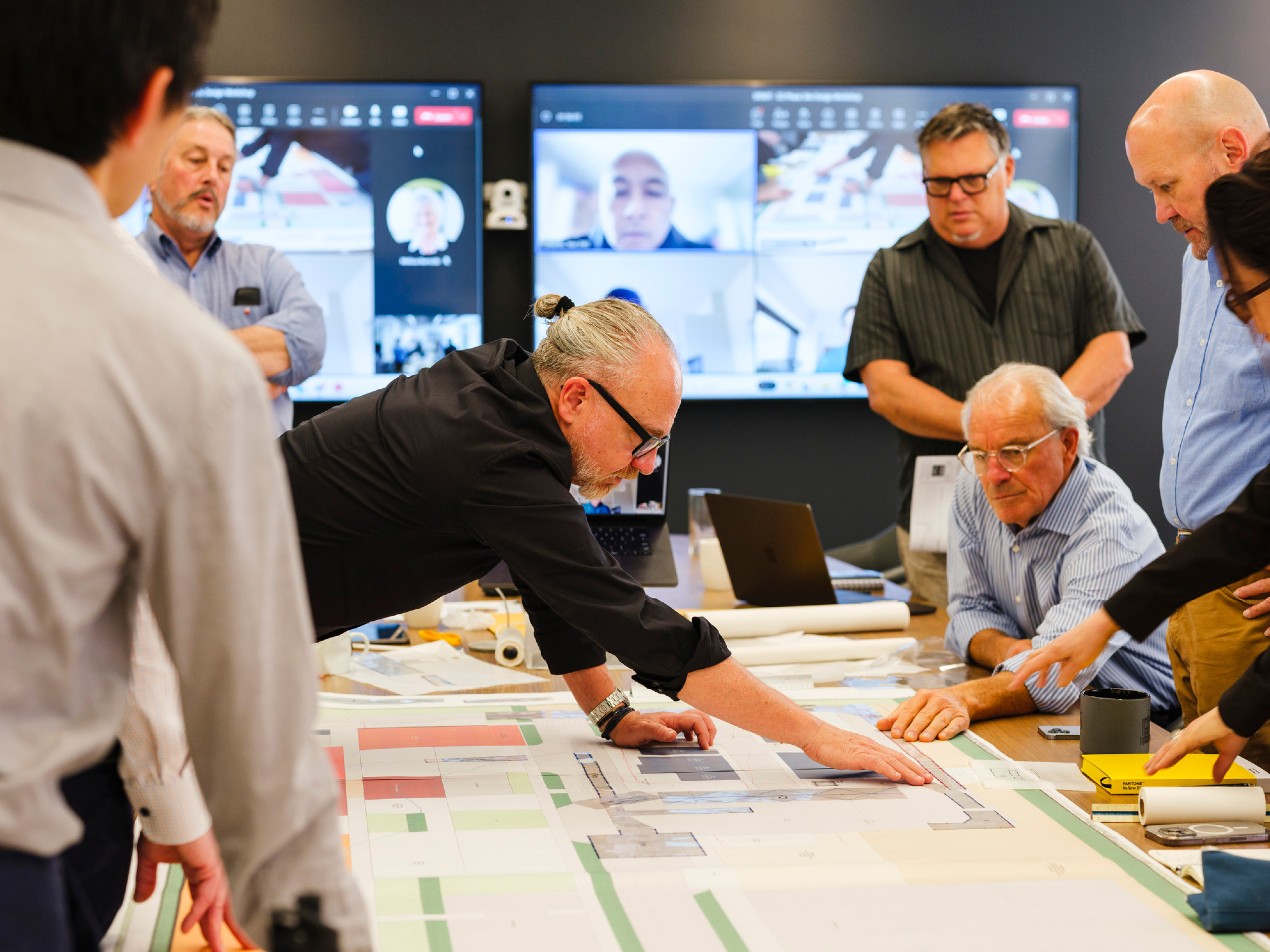 people collaborating over a schematic design at a table; DLR Group San Francisco office