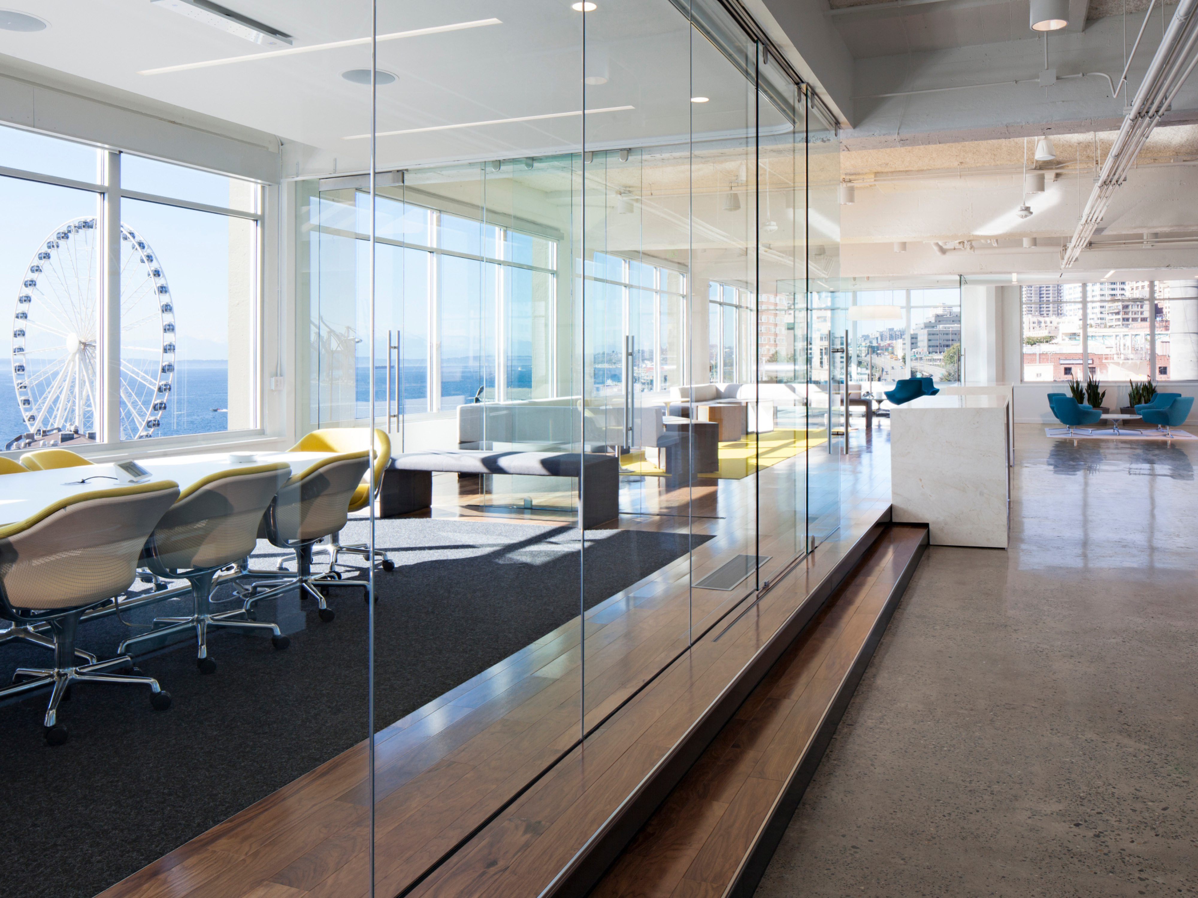 modern bright, airy office with multiple collaboration zones overlooking the water and a ferris wheel; DLR Group seattle office
