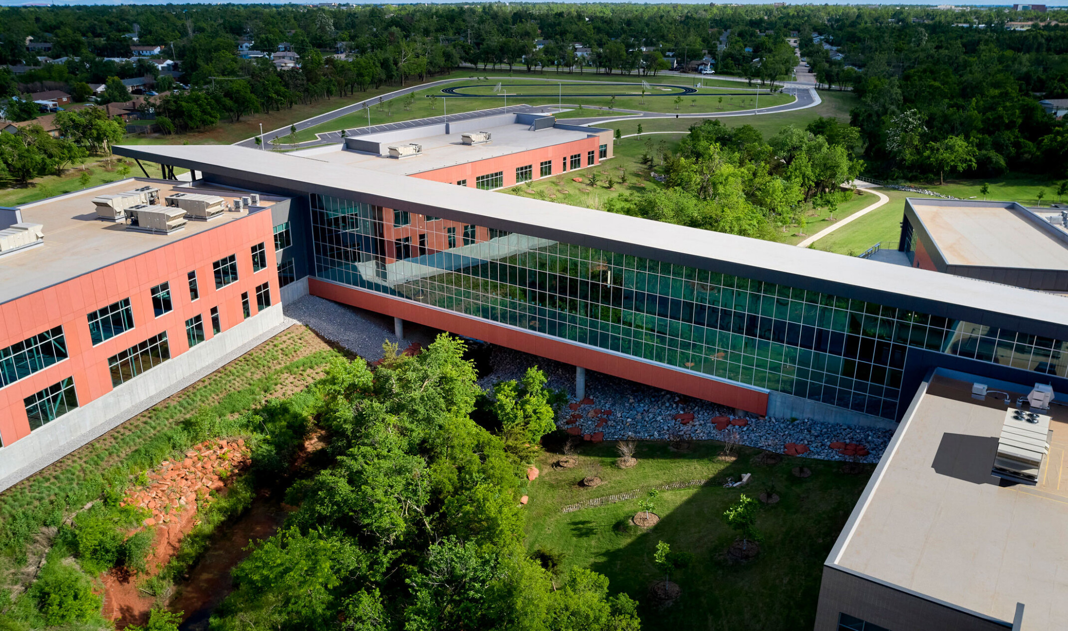 Aerial view of site focused on the long hallway with double height windows connecting two building sections