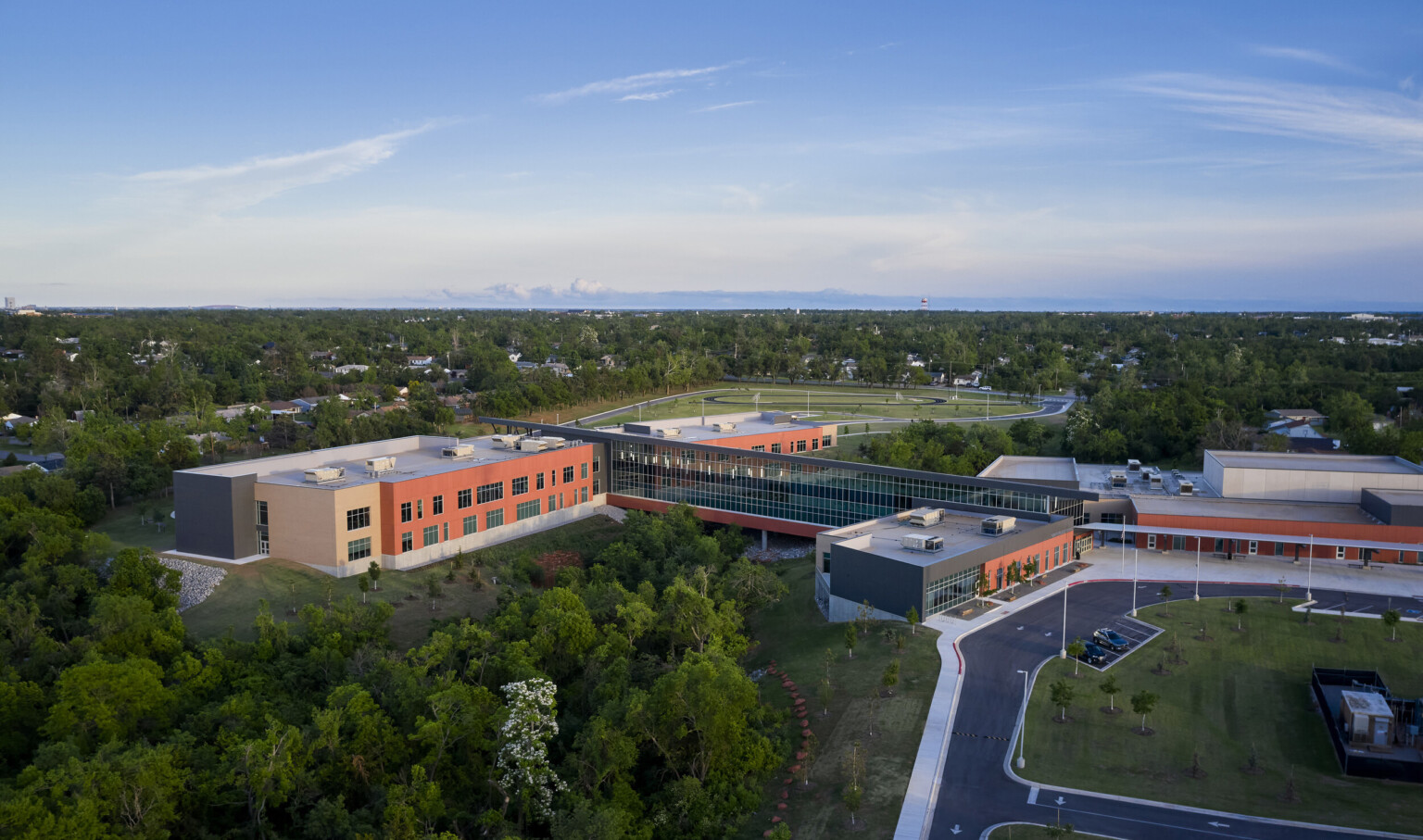 Capps Middle School viewed from above. A round driveway leads to front entrance. A long windowed hall connects 2 buildings
