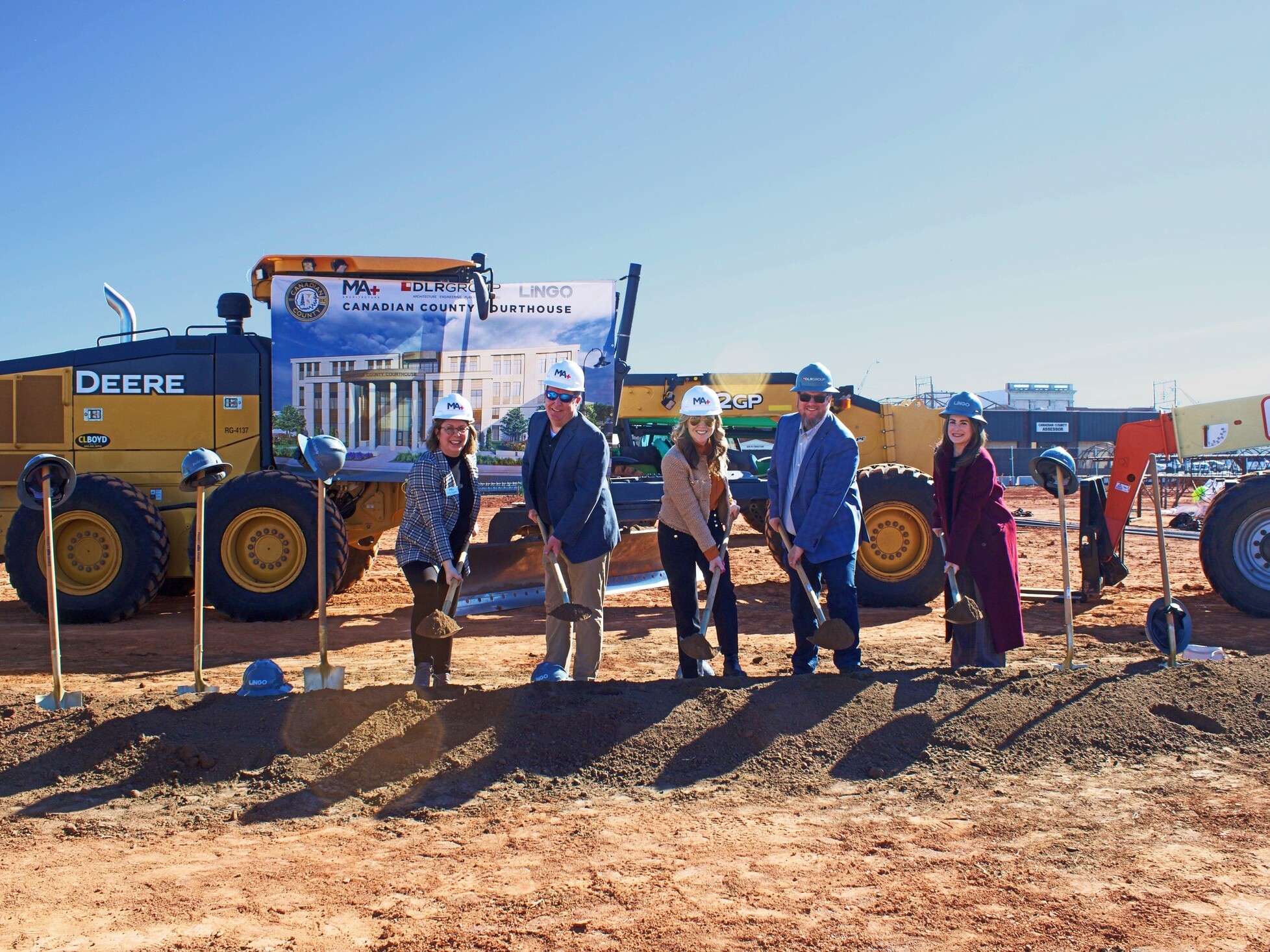 5 people standing in front of a construction site with a ceremonial pile of dirt to represent groundbreaking at Canadian County Courthouse