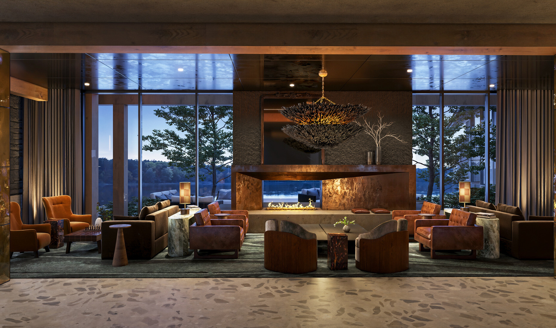 interior of a lodge-themed hotel lobby; rustic columns; stone walls; dark leather and wood interior tables and booths